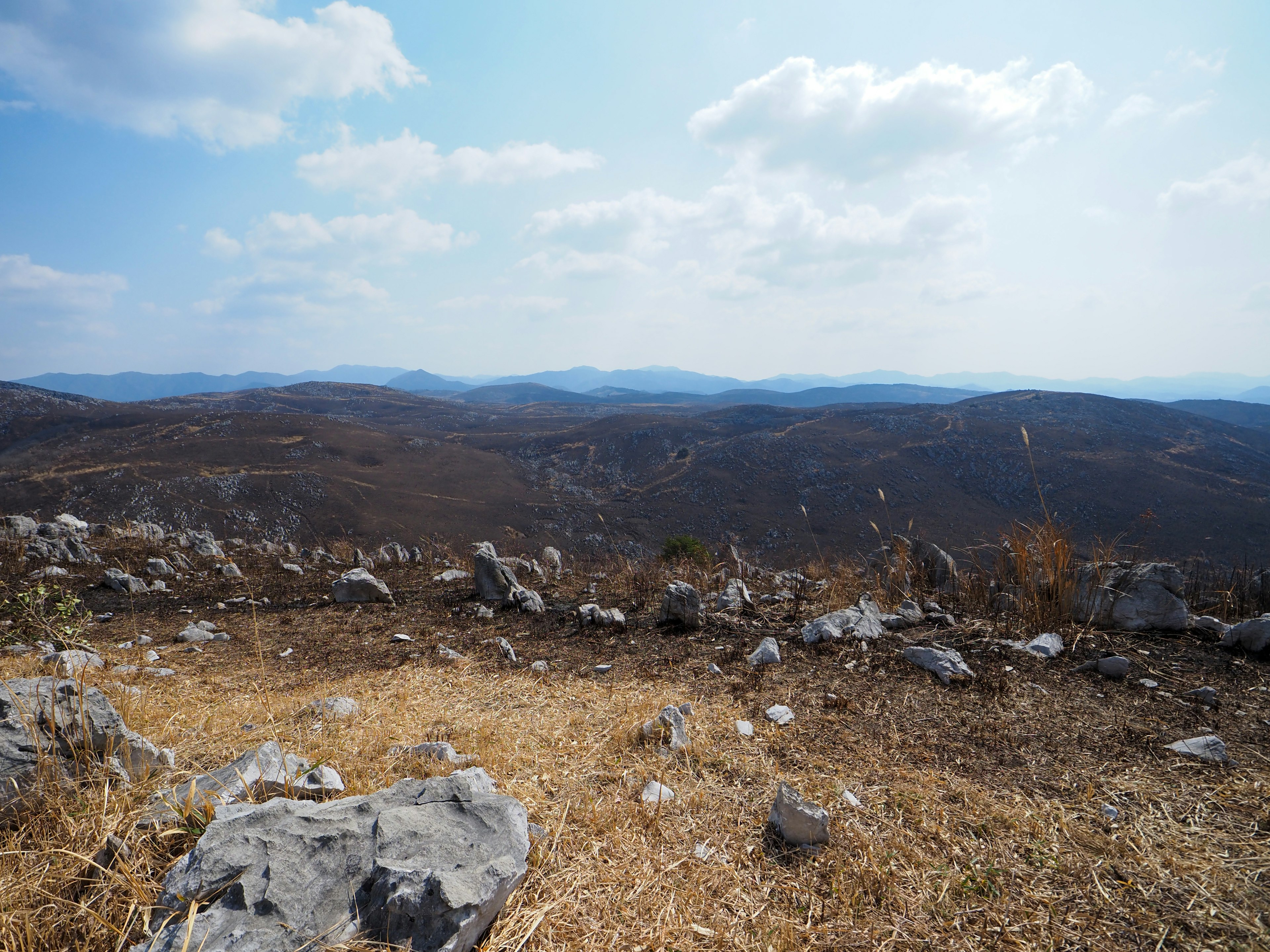 Weite Berglandschaft mit felsigem Terrain und blauem Himmel