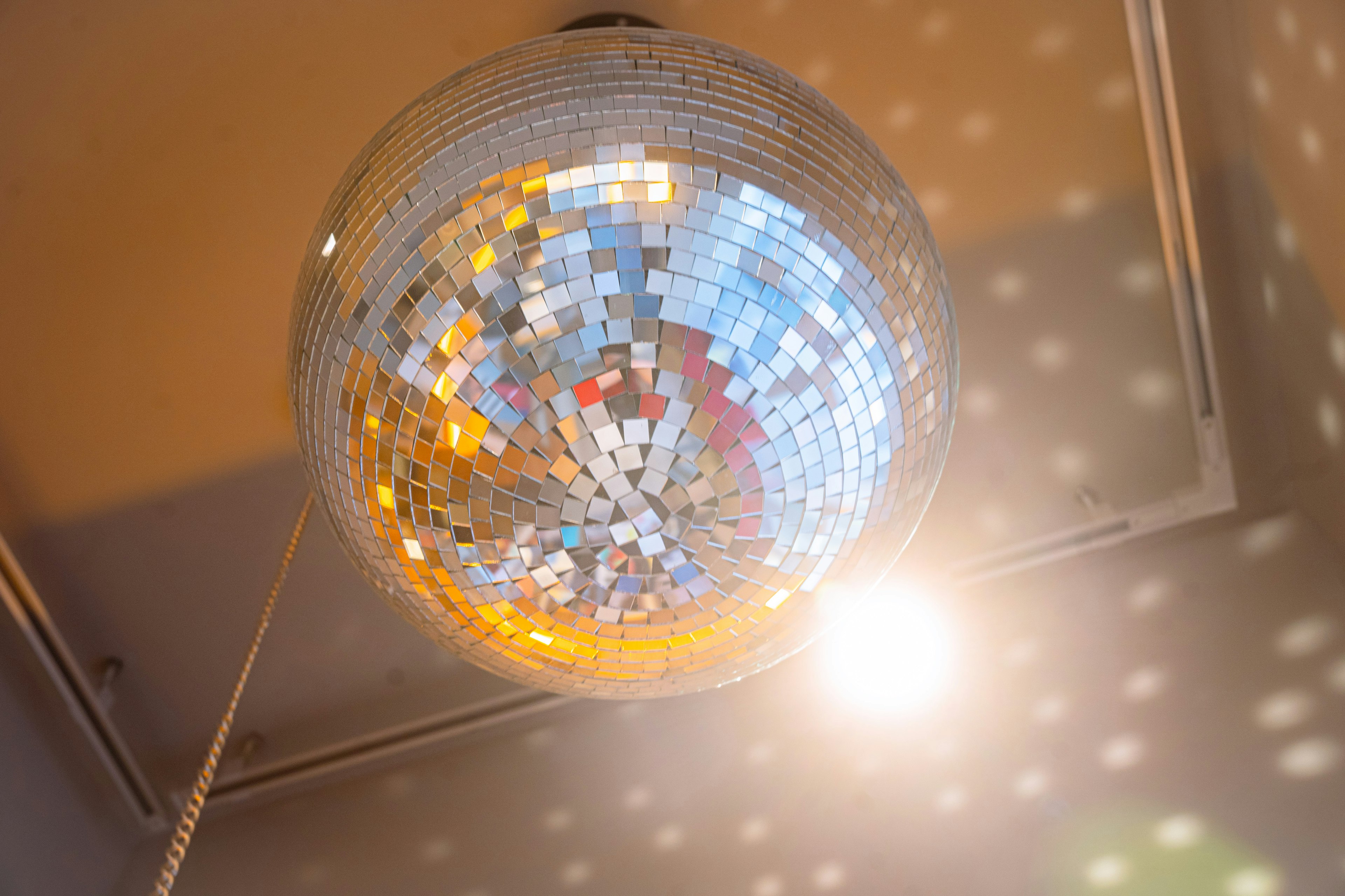 A disco ball reflecting light hanging from the ceiling