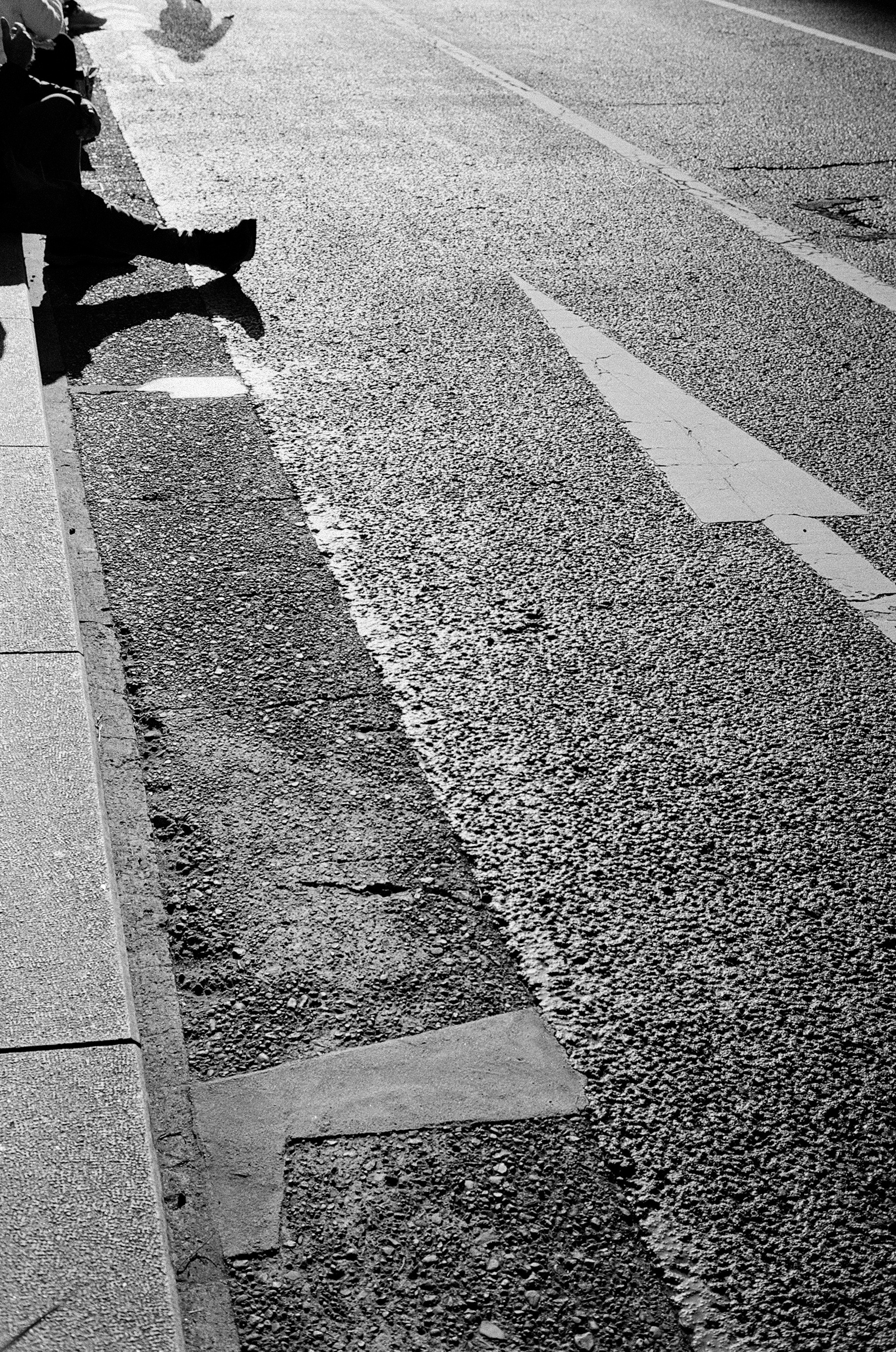 Imagen en blanco y negro que muestra parte de una carretera con una marca de flecha