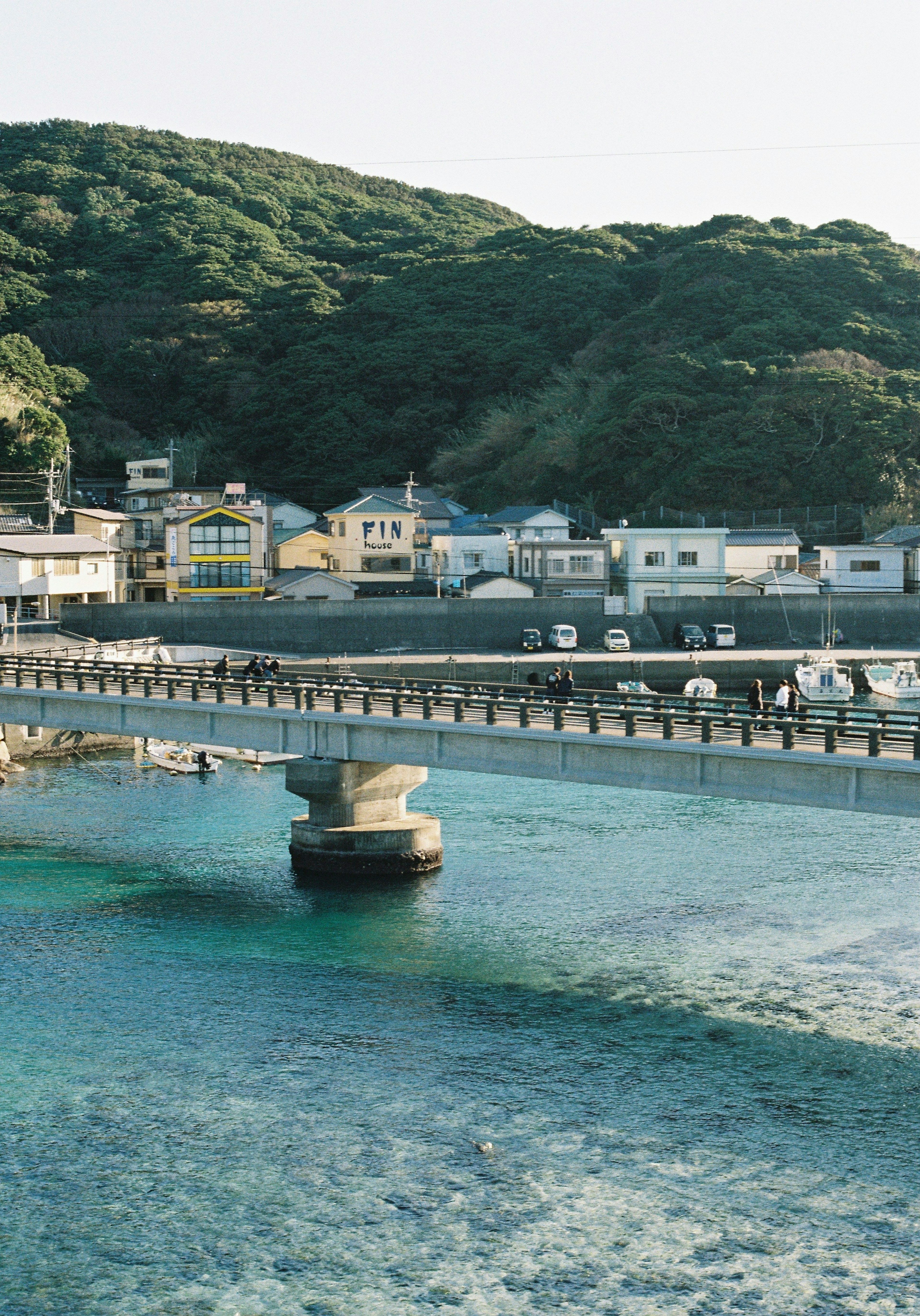 清澈水面上方的桥梁风景，四周环绕着山丘