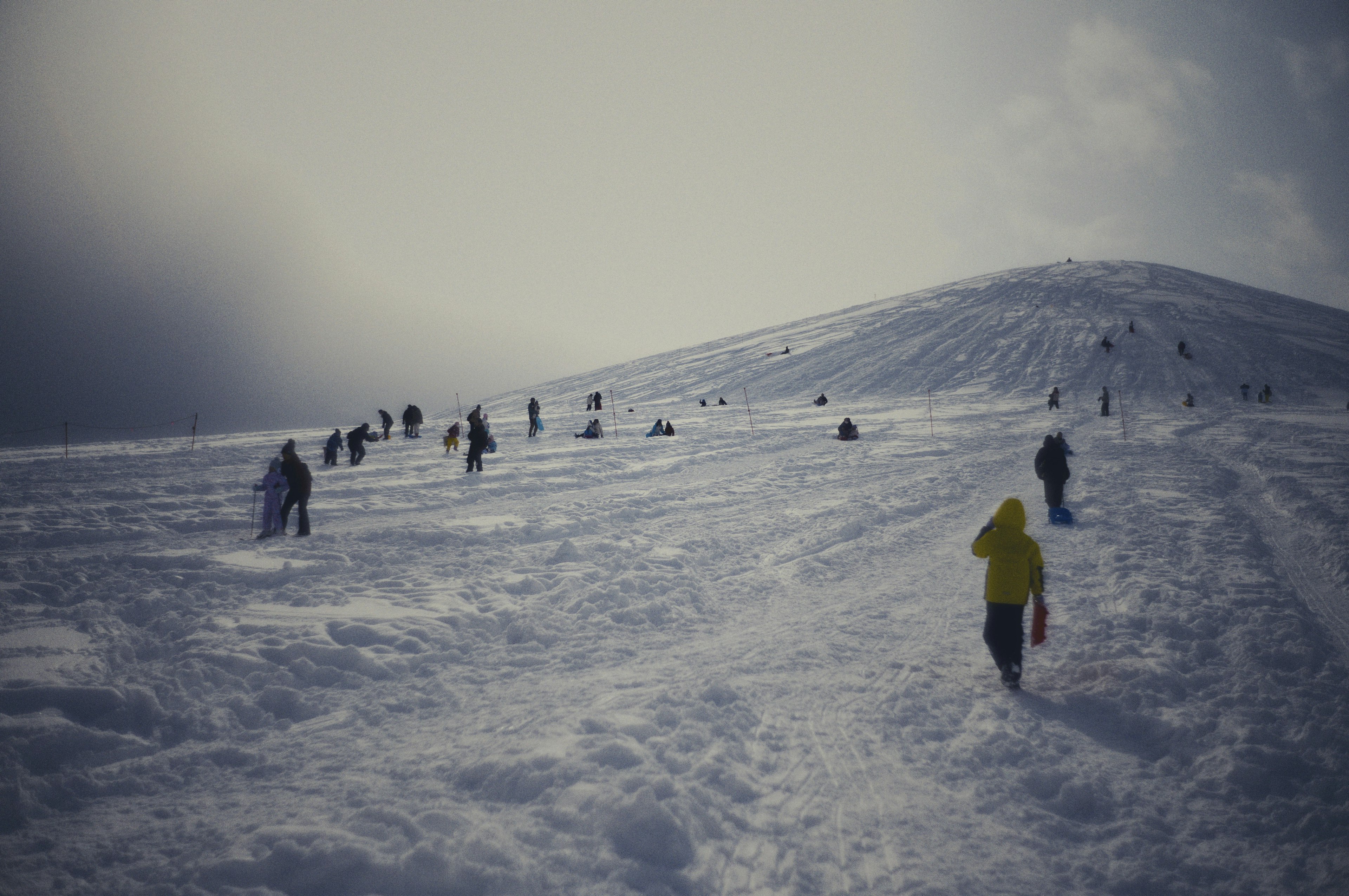 Persone che scalano una collina coperta di neve in inverno