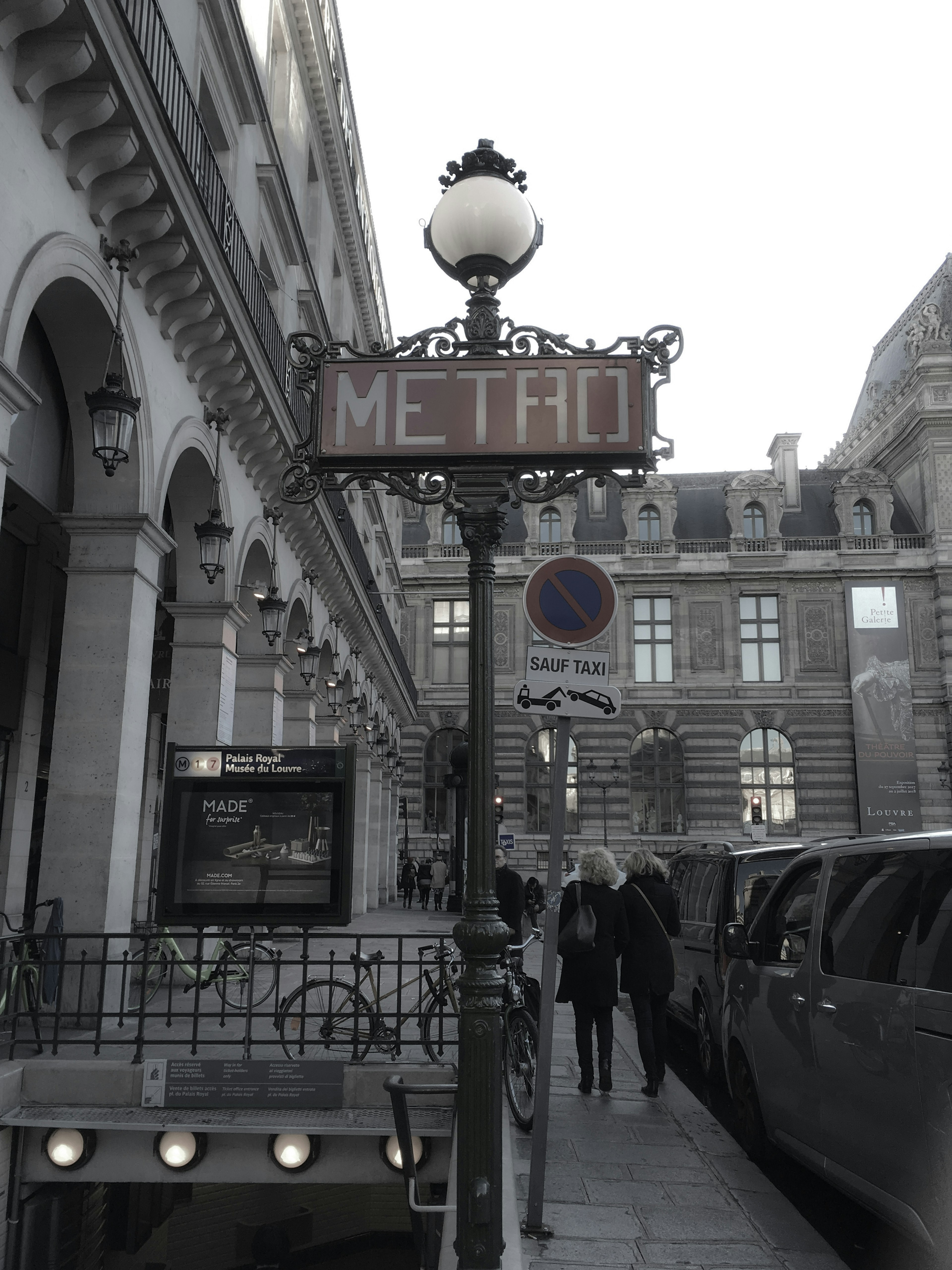 Panneau du Métro de Paris avec des bâtiments historiques en arrière-plan