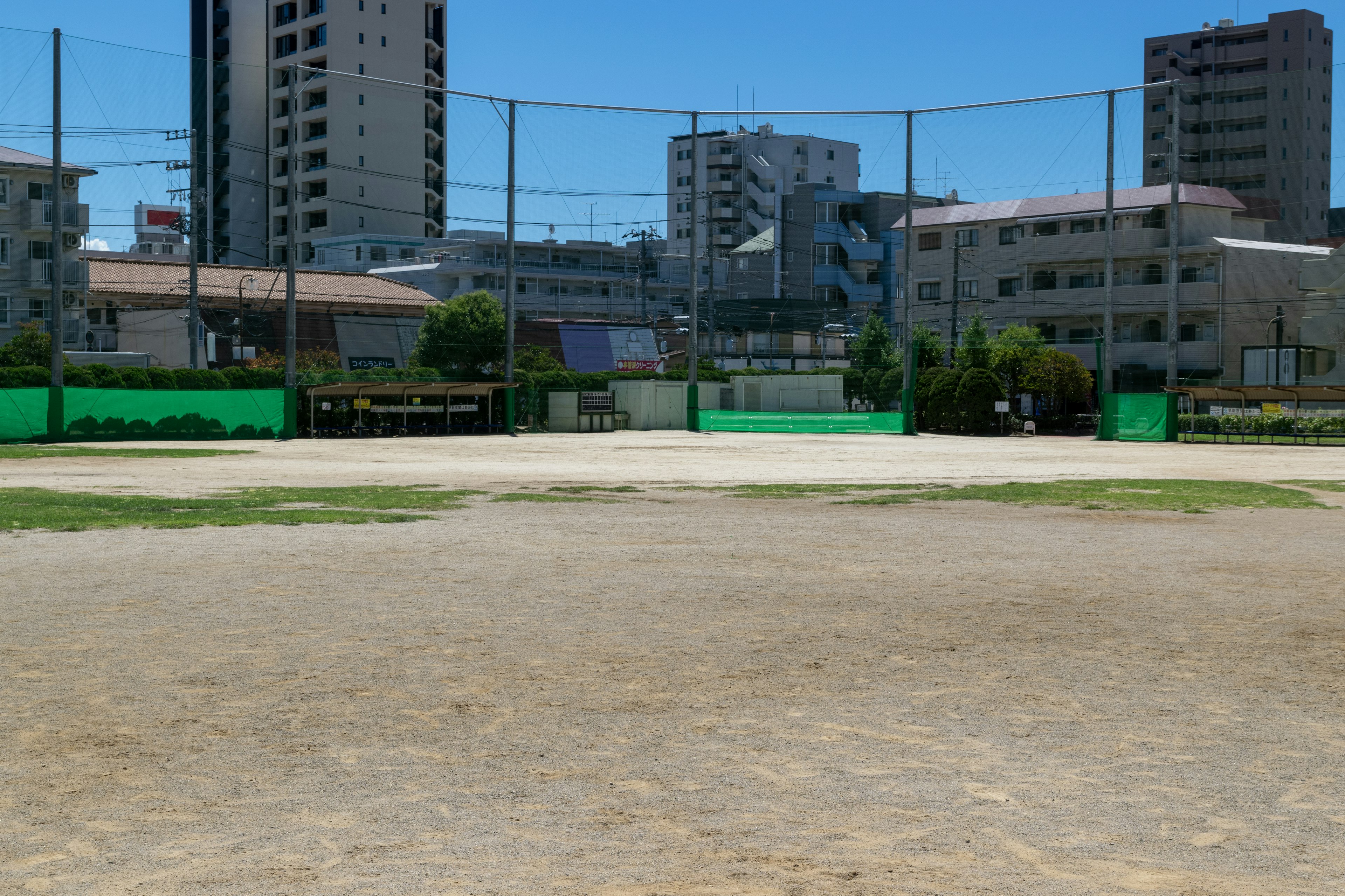 Campo da baseball sotto un cielo blu con edifici circostanti