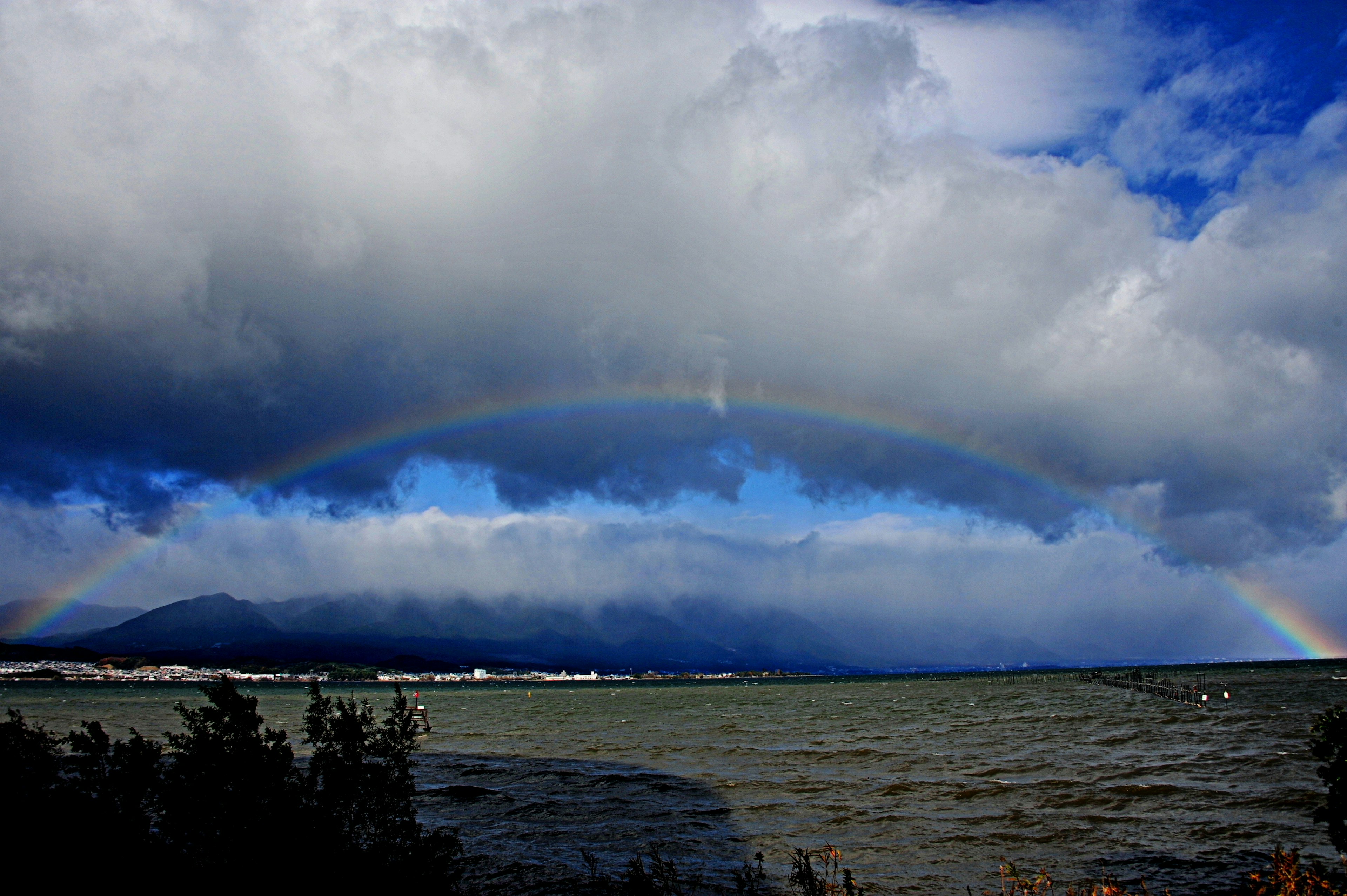 A beautiful rainbow visible between clouds