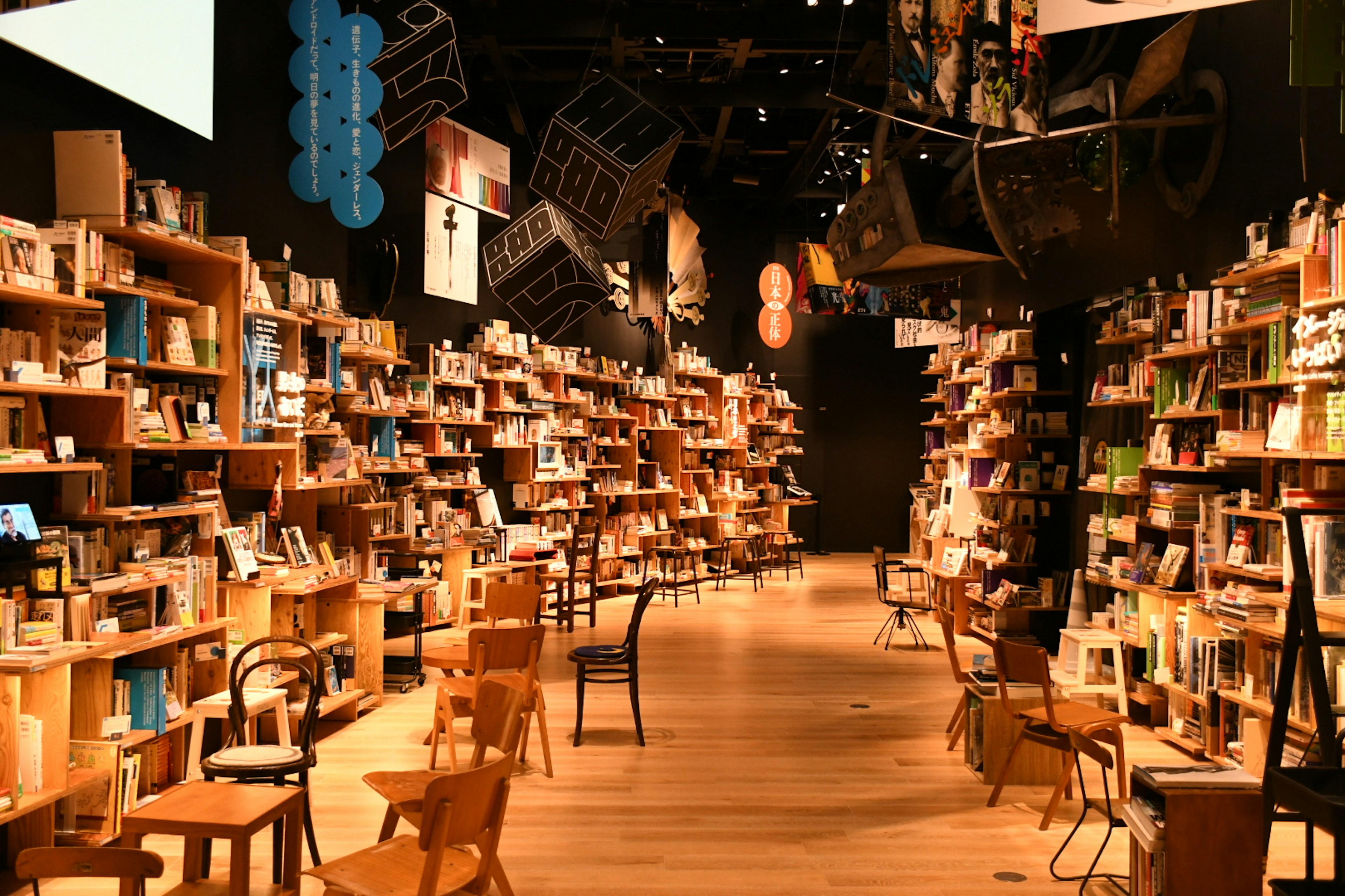 Interior de una librería con estanterías de madera llenas de libros y sillas