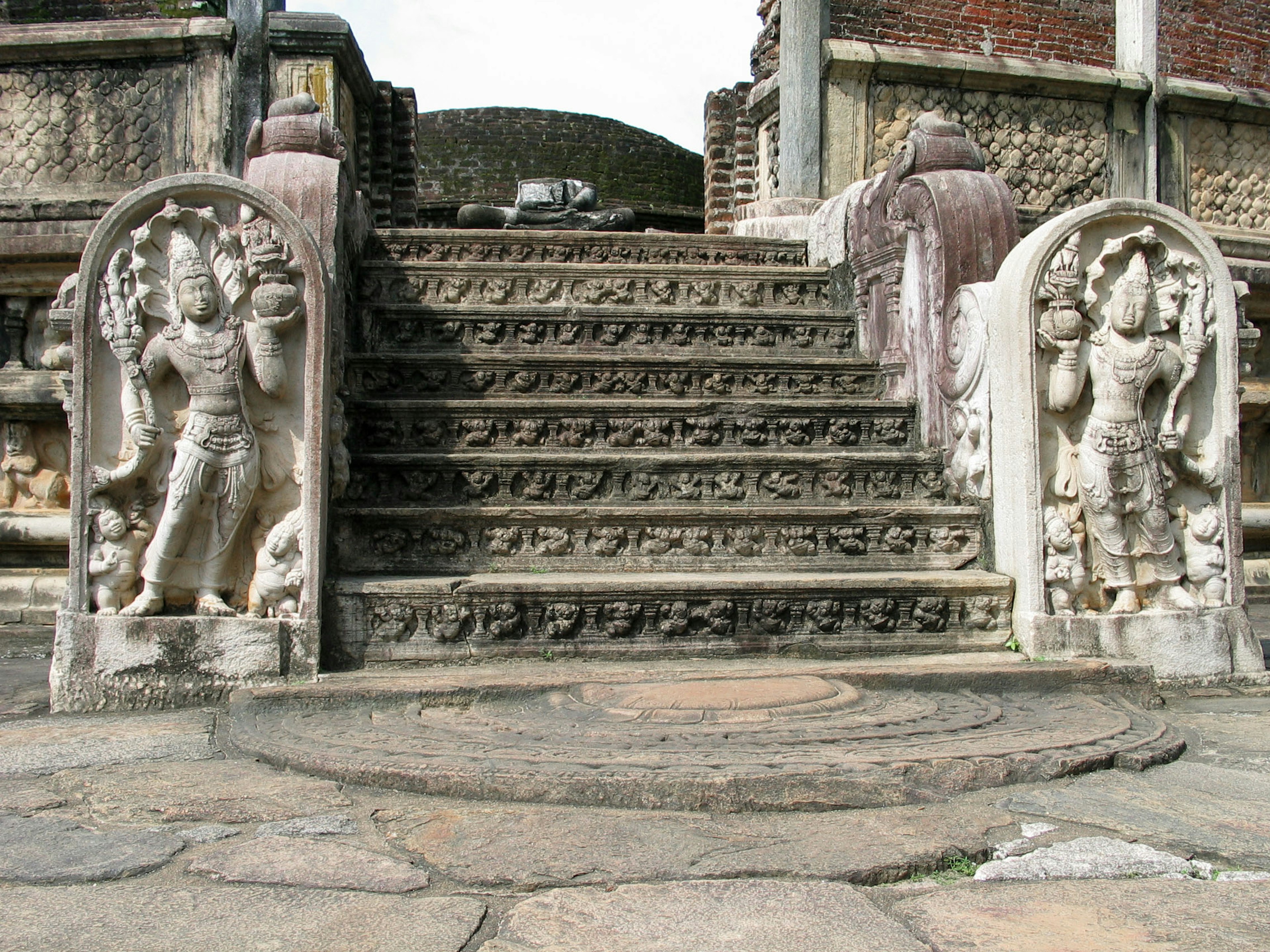 Estatuas de piedra talladas y elementos decorativos en las escaleras de un templo antiguo