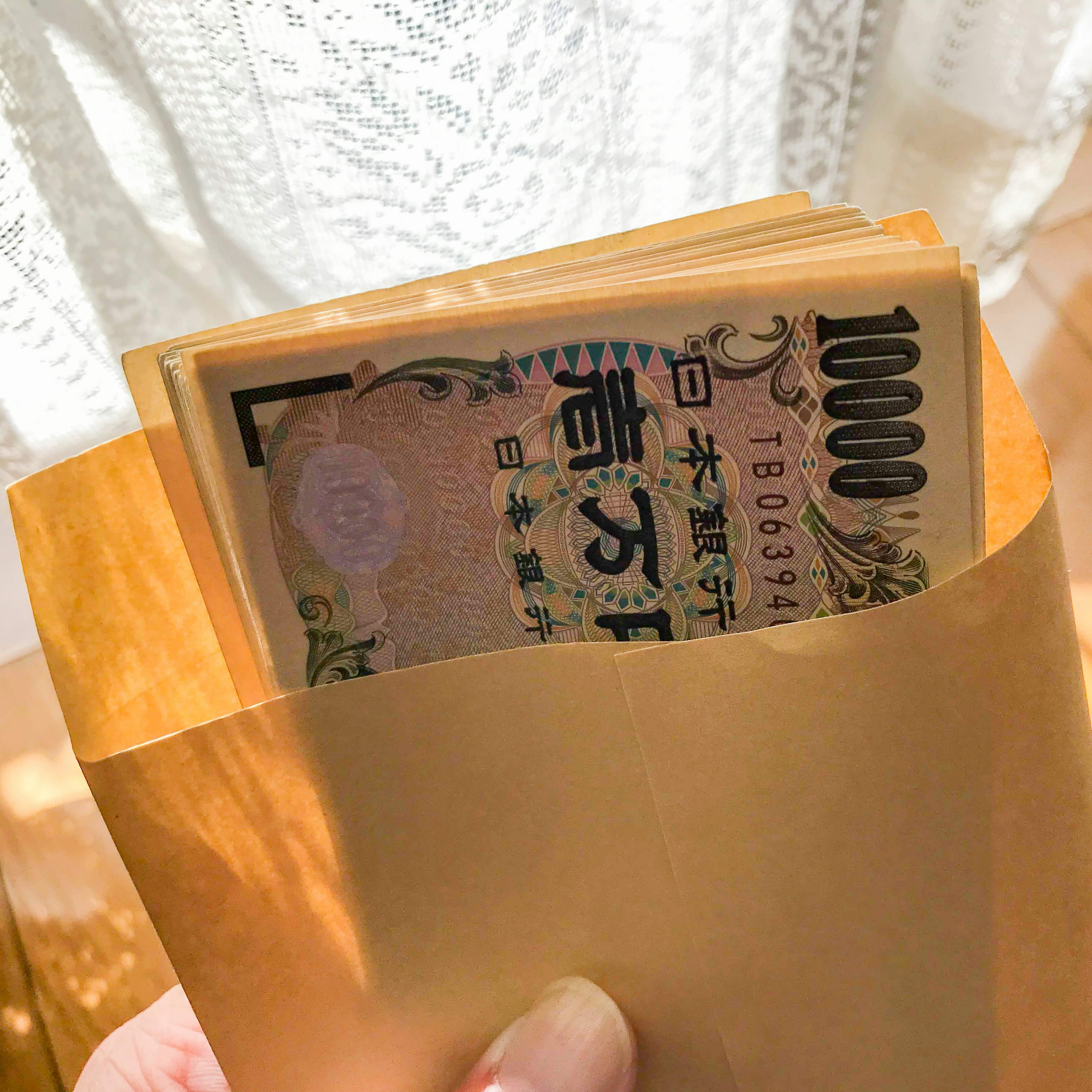 A bundle of Japanese 1000 yen bills inside a golden envelope