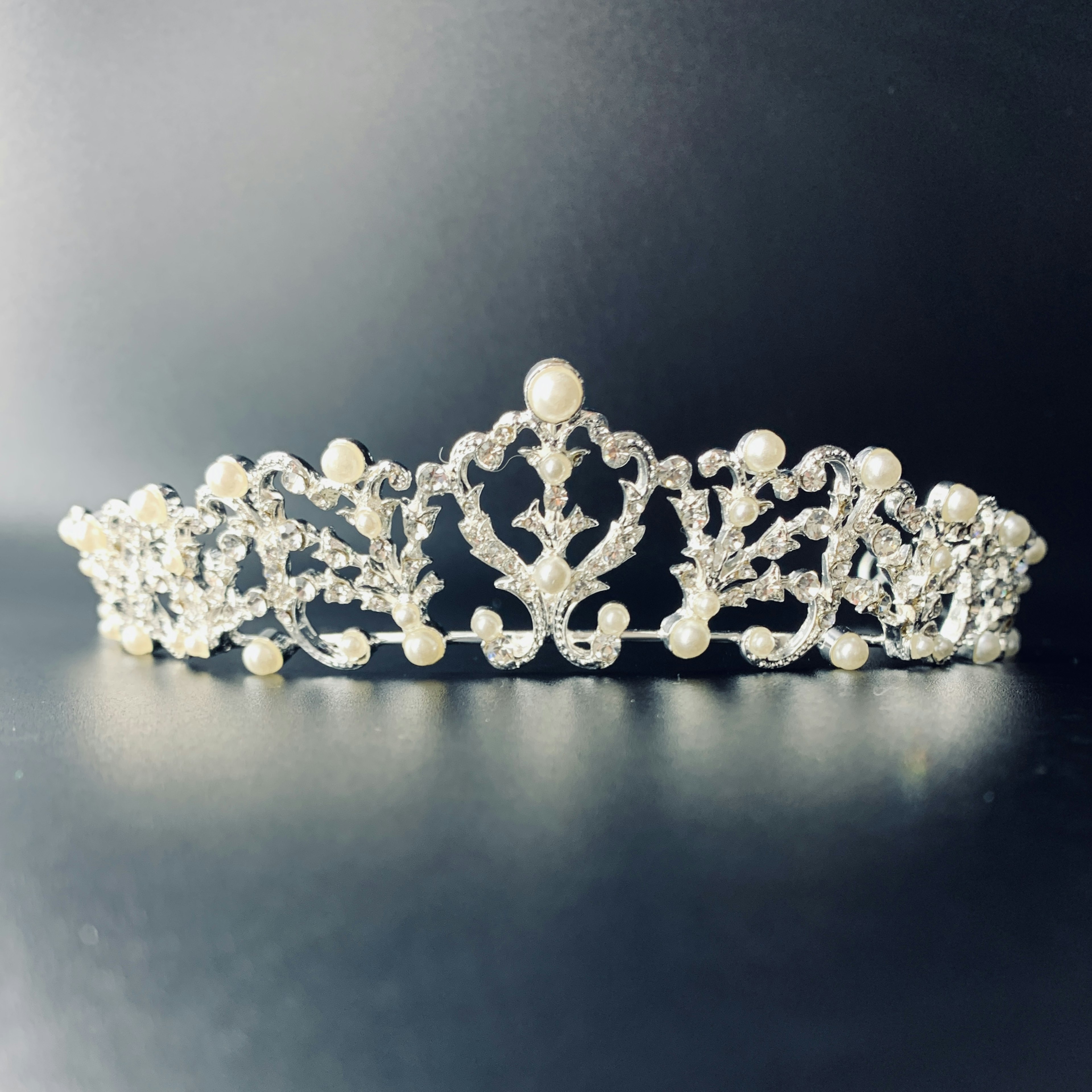 Une délicate tiara en argent ornée de perles et de décorations en cristal