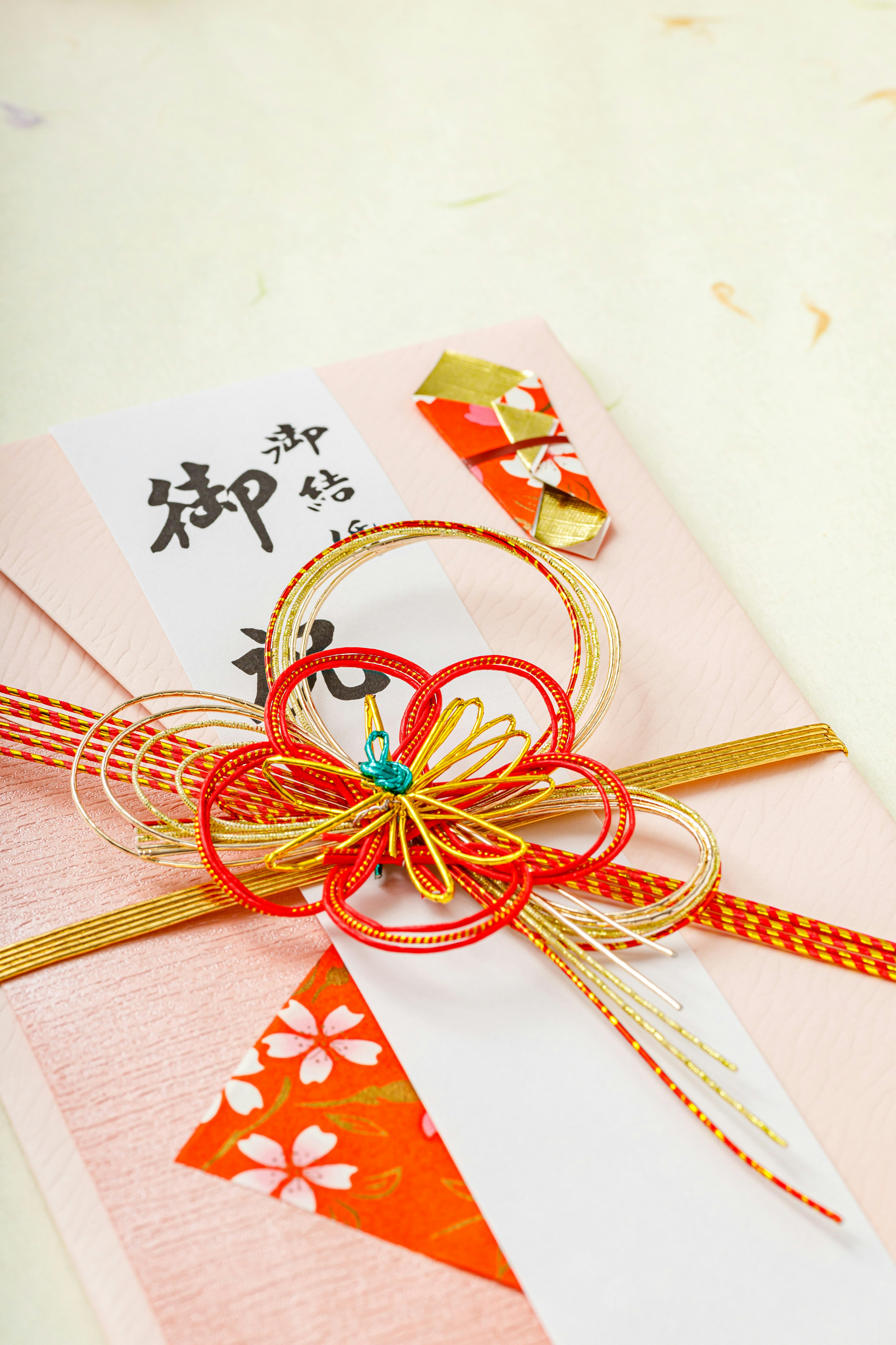 Elegant Japanese gift wrapping with colorful decorations and gold ribbon