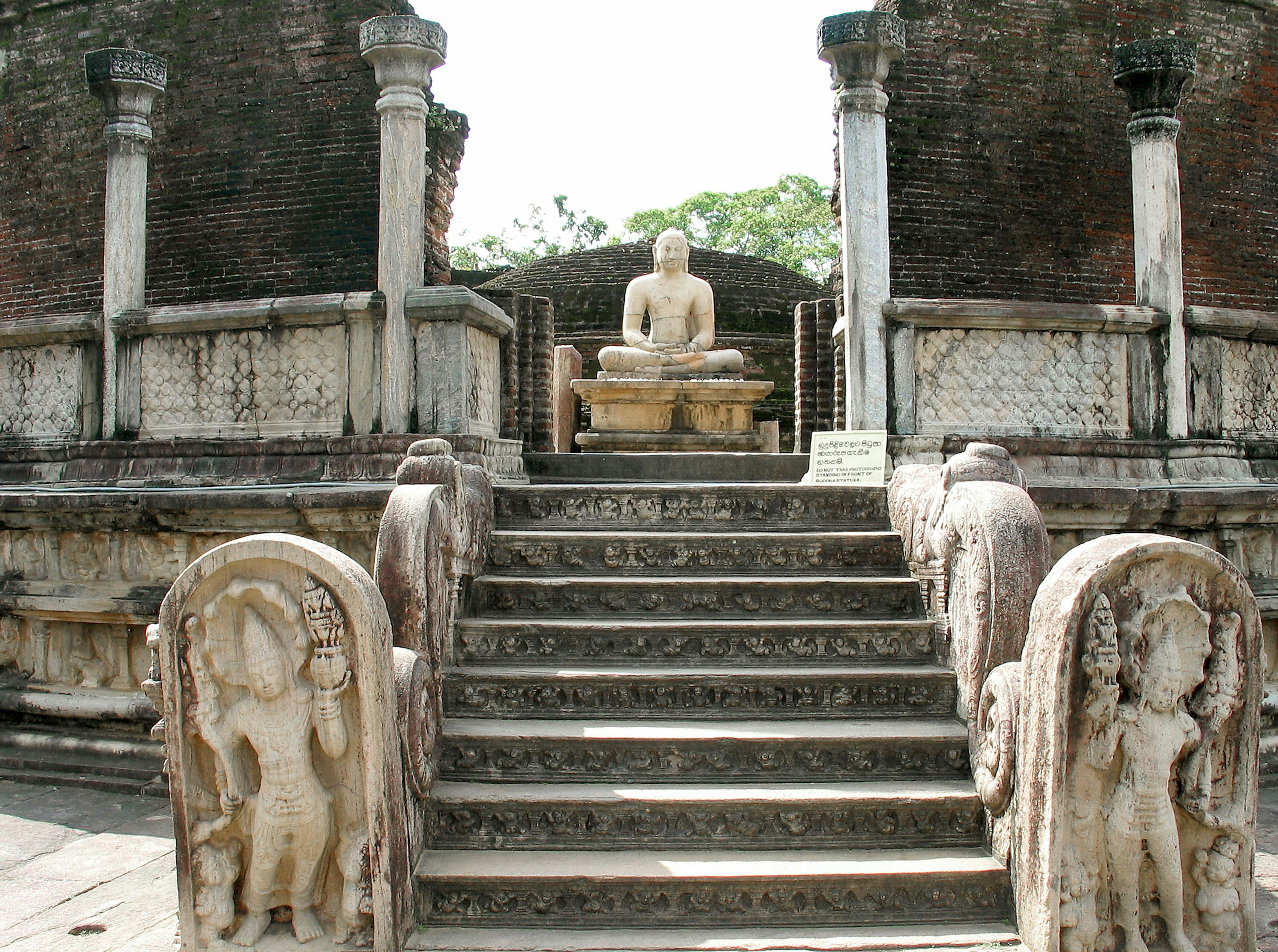 Kuil kuno dengan tangga batu menuju patung Buddha yang duduk