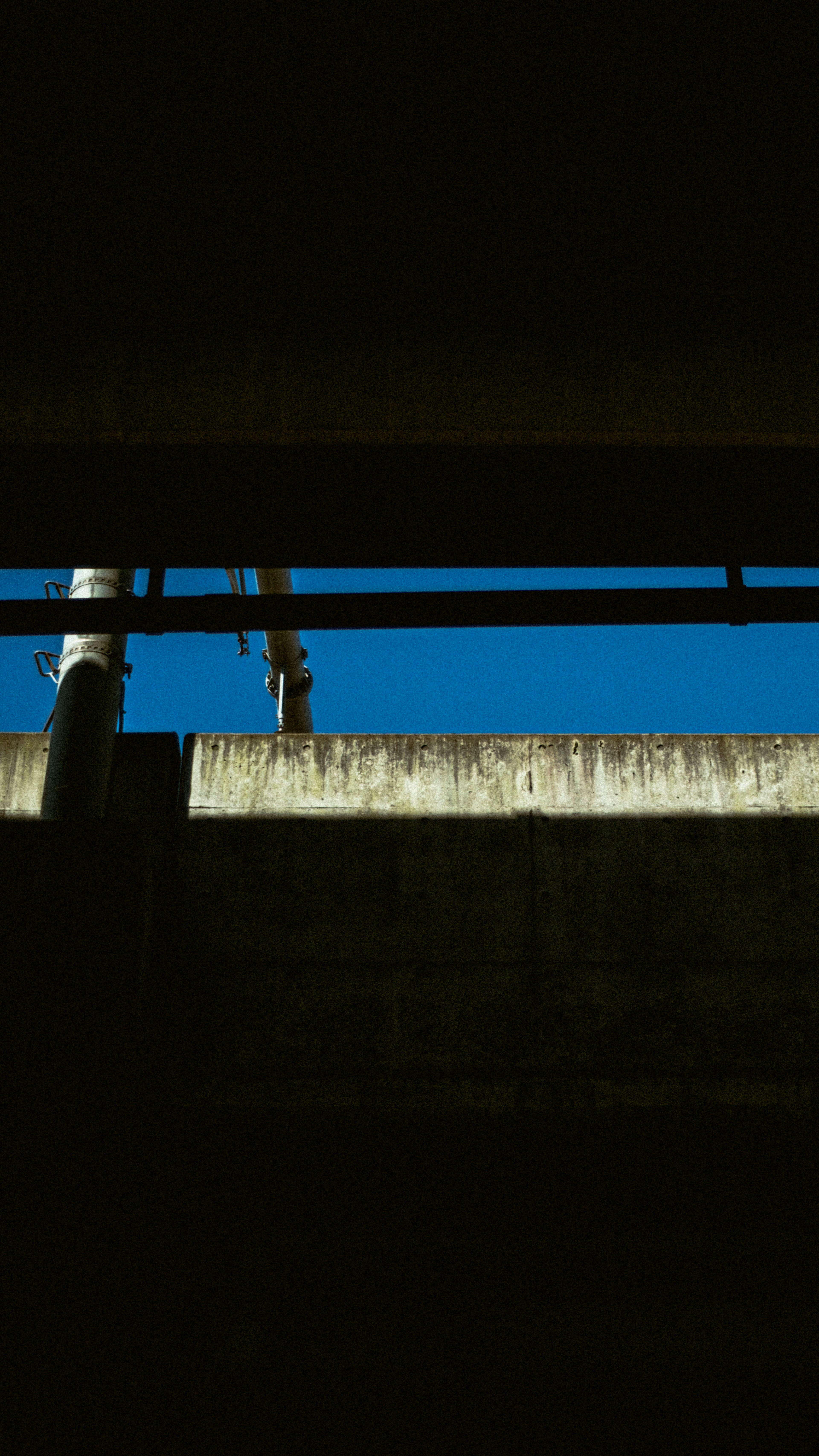 Silhouette of industrial structures against a blue sky