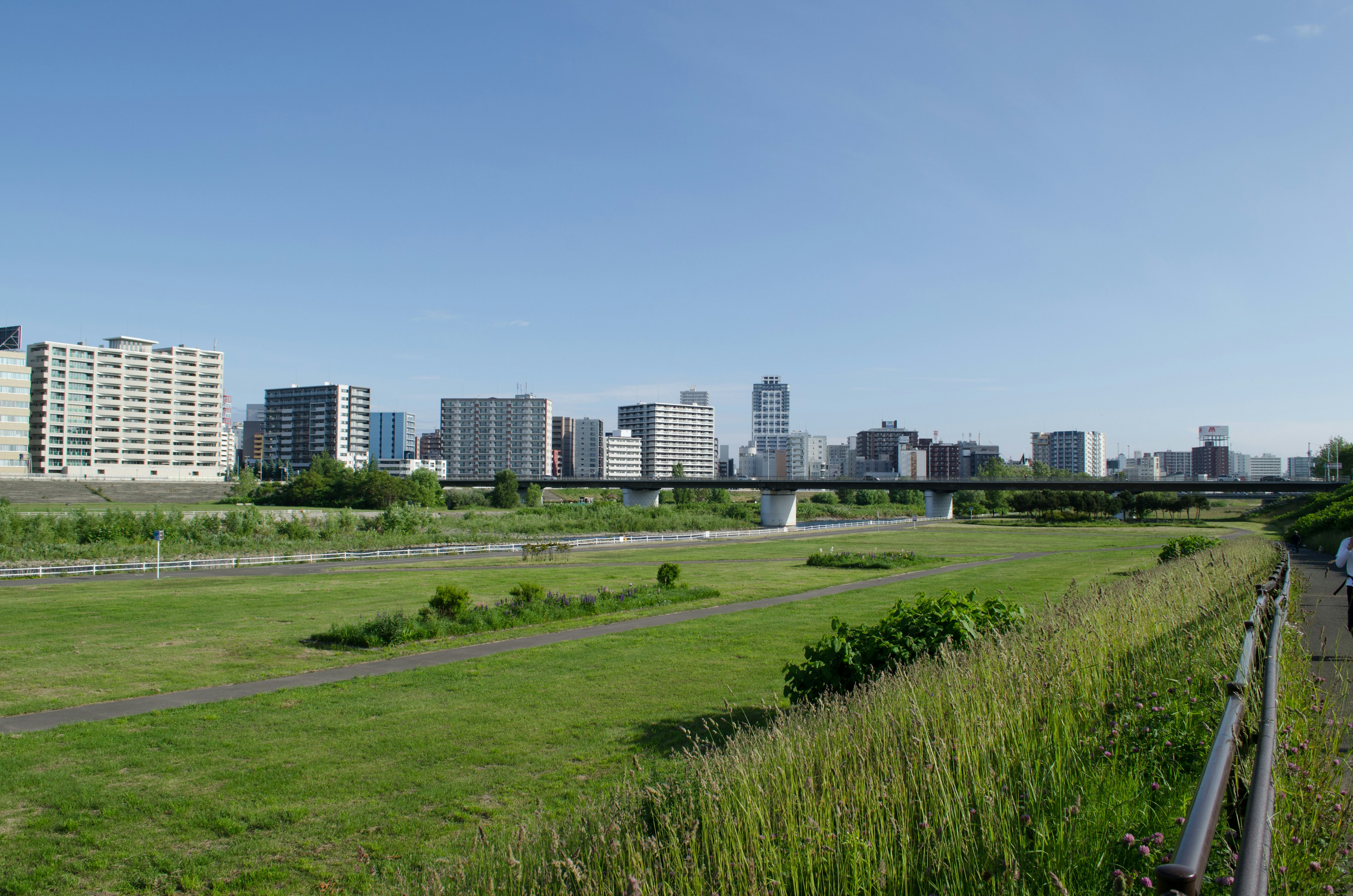 Paysage urbain sous un ciel bleu avec une zone de gazon vert