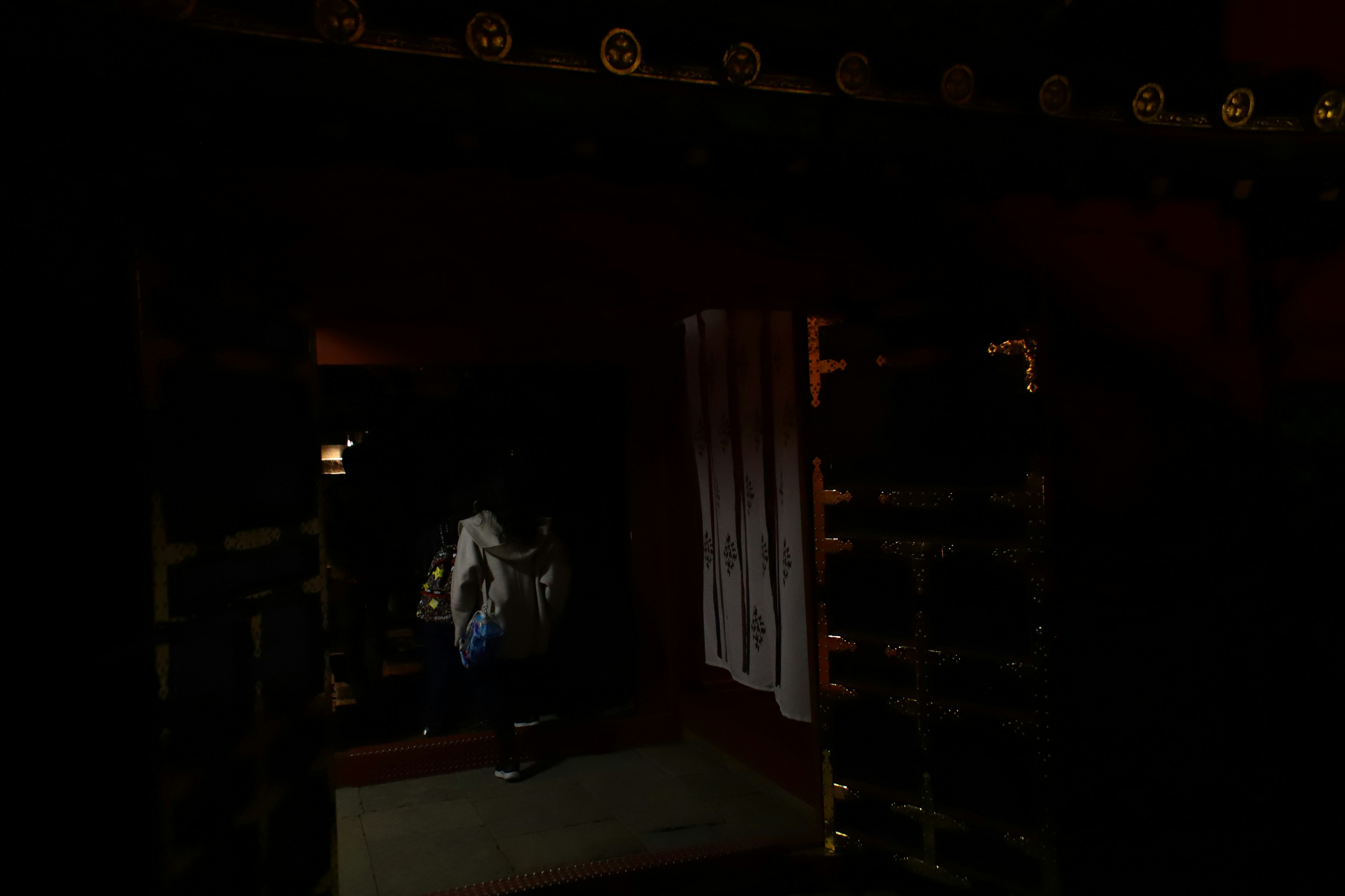 Entrance of a traditional Japanese building in a dark setting with dim interior