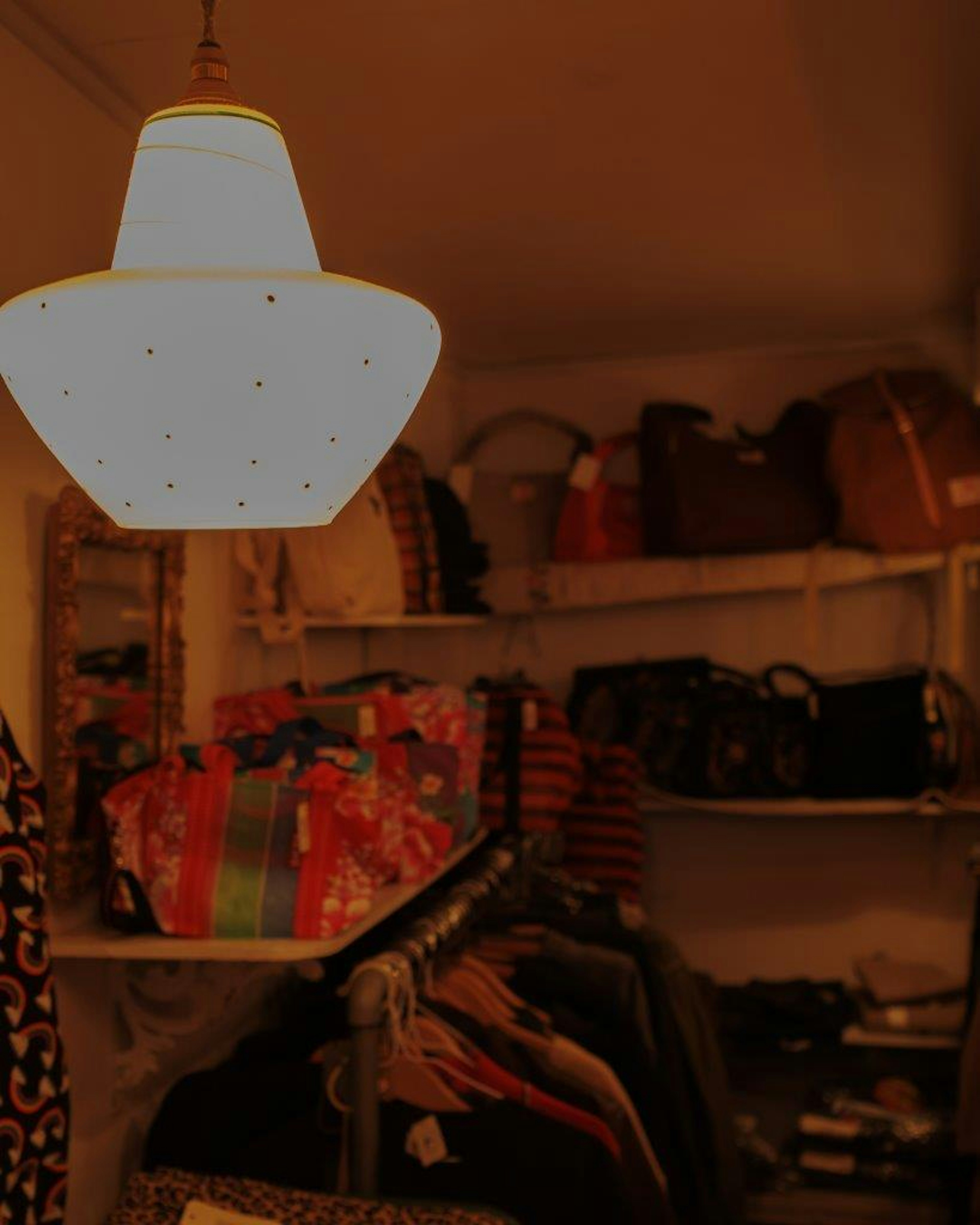 Interior de un armario con iluminación brillante que presenta bolsas y ropa organizadas