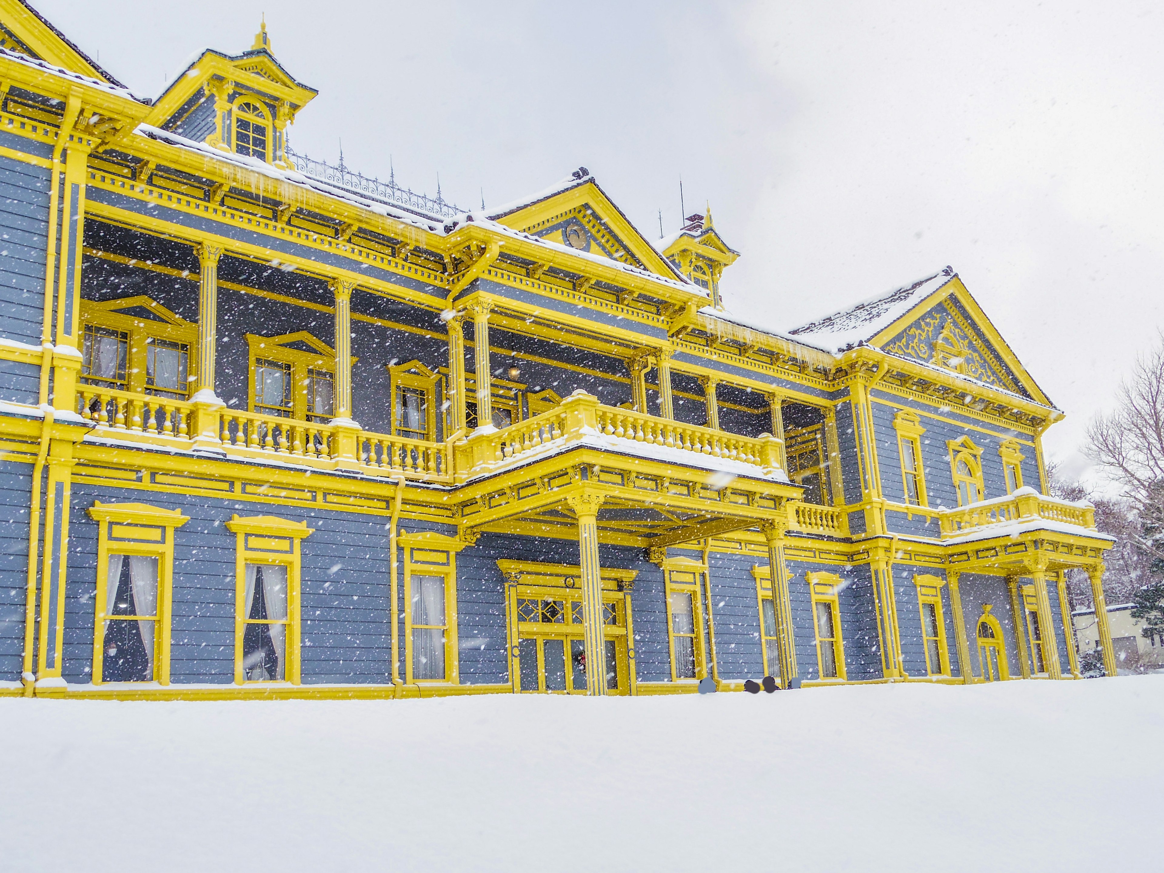 Luxueux manoir bleu et jaune dans la neige