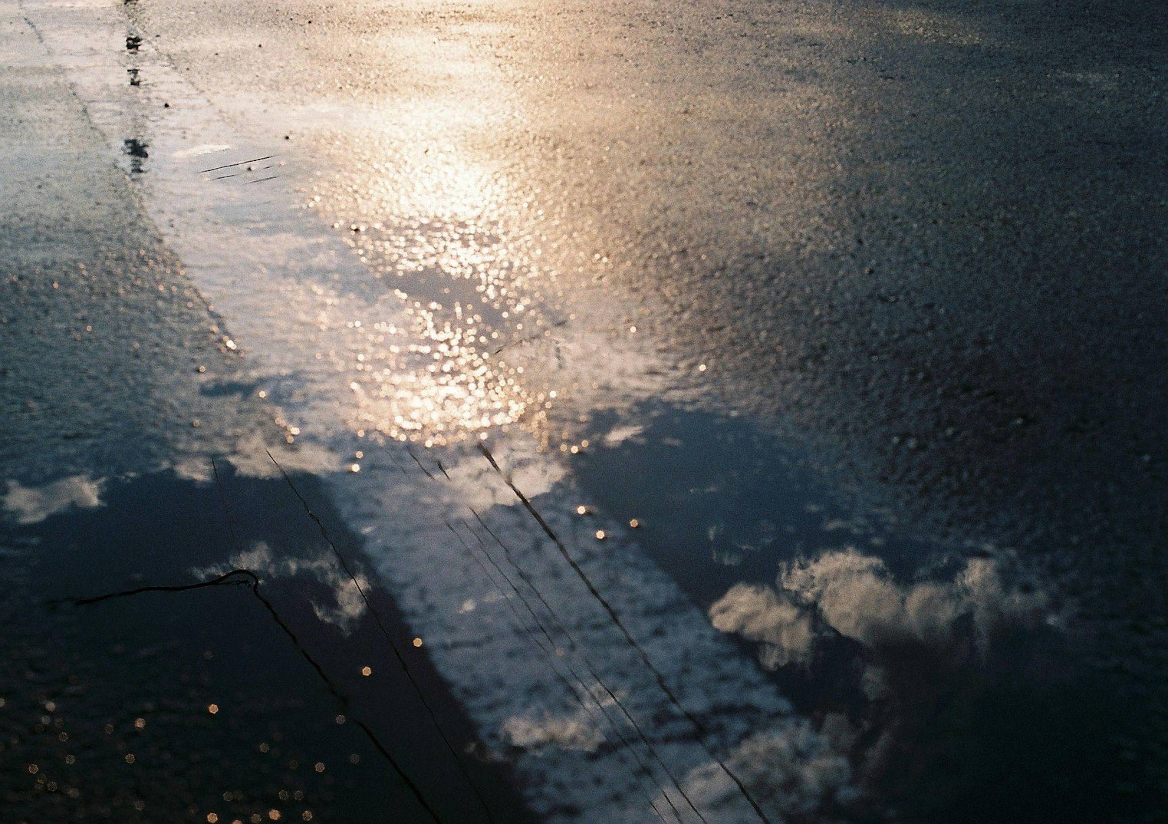 Reflexion von Licht und Wolken in einer Pfütze