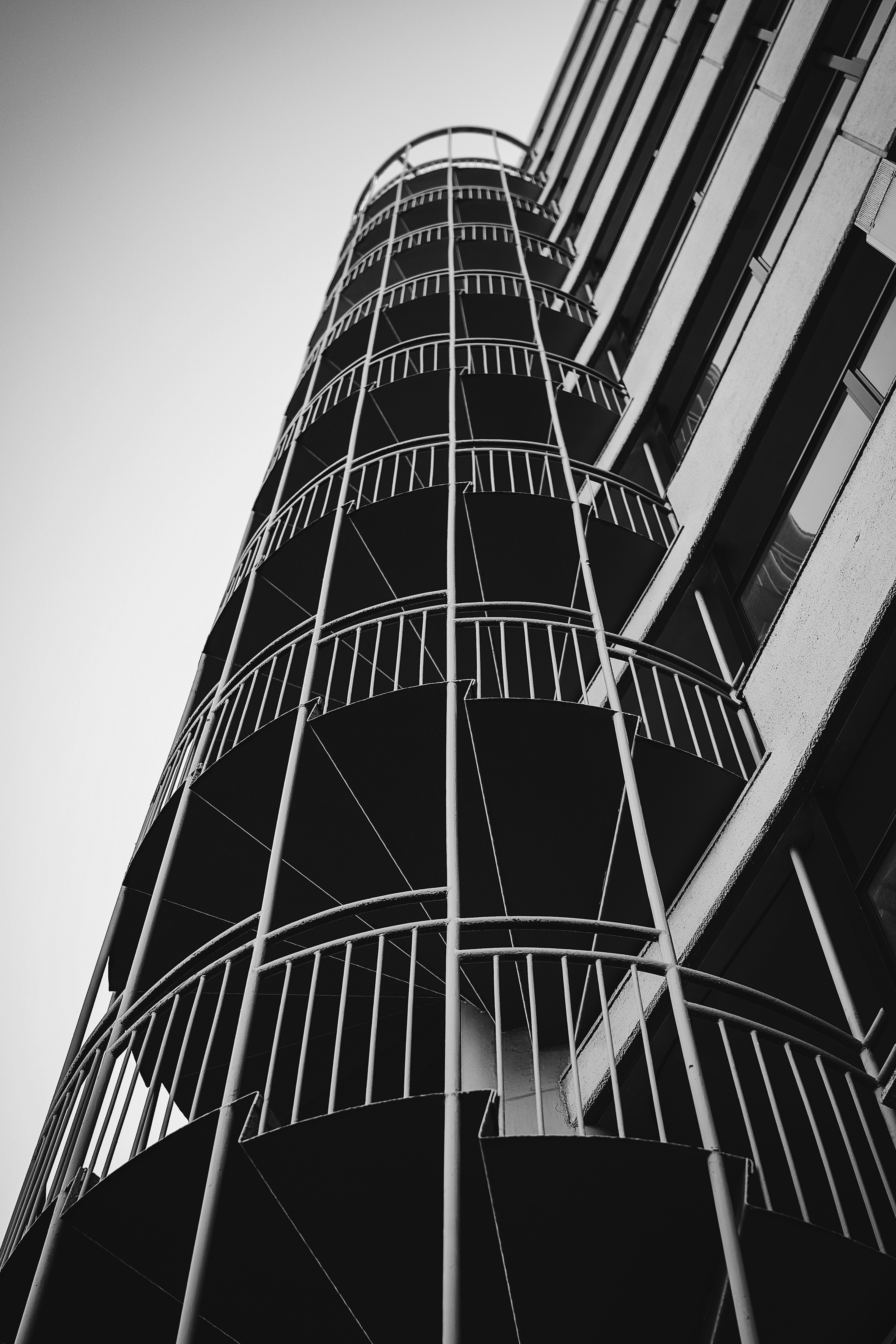 Image of a spiral staircase on a building viewed from below in black and white