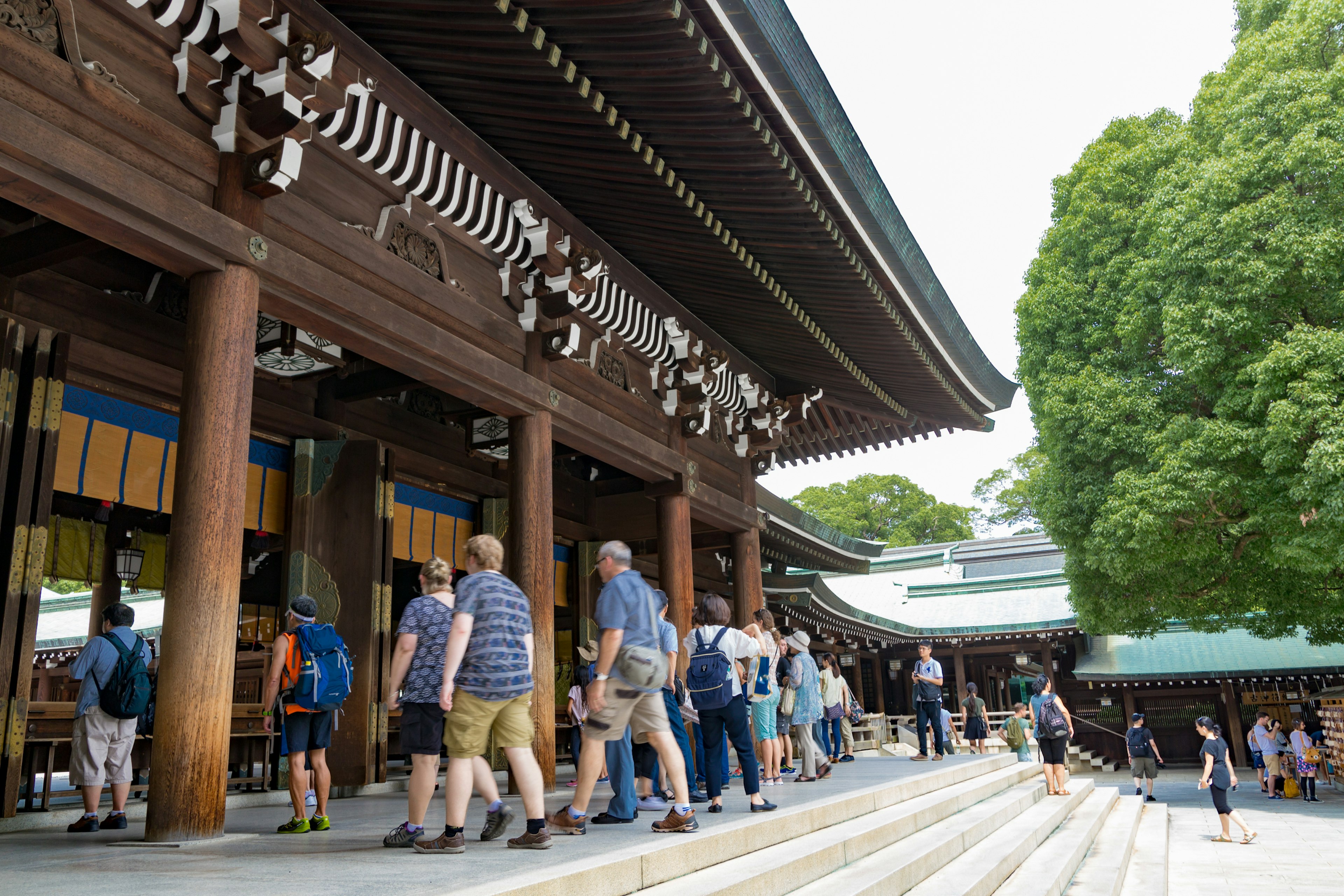 Des gens montant les marches d'un sanctuaire avec une architecture traditionnelle