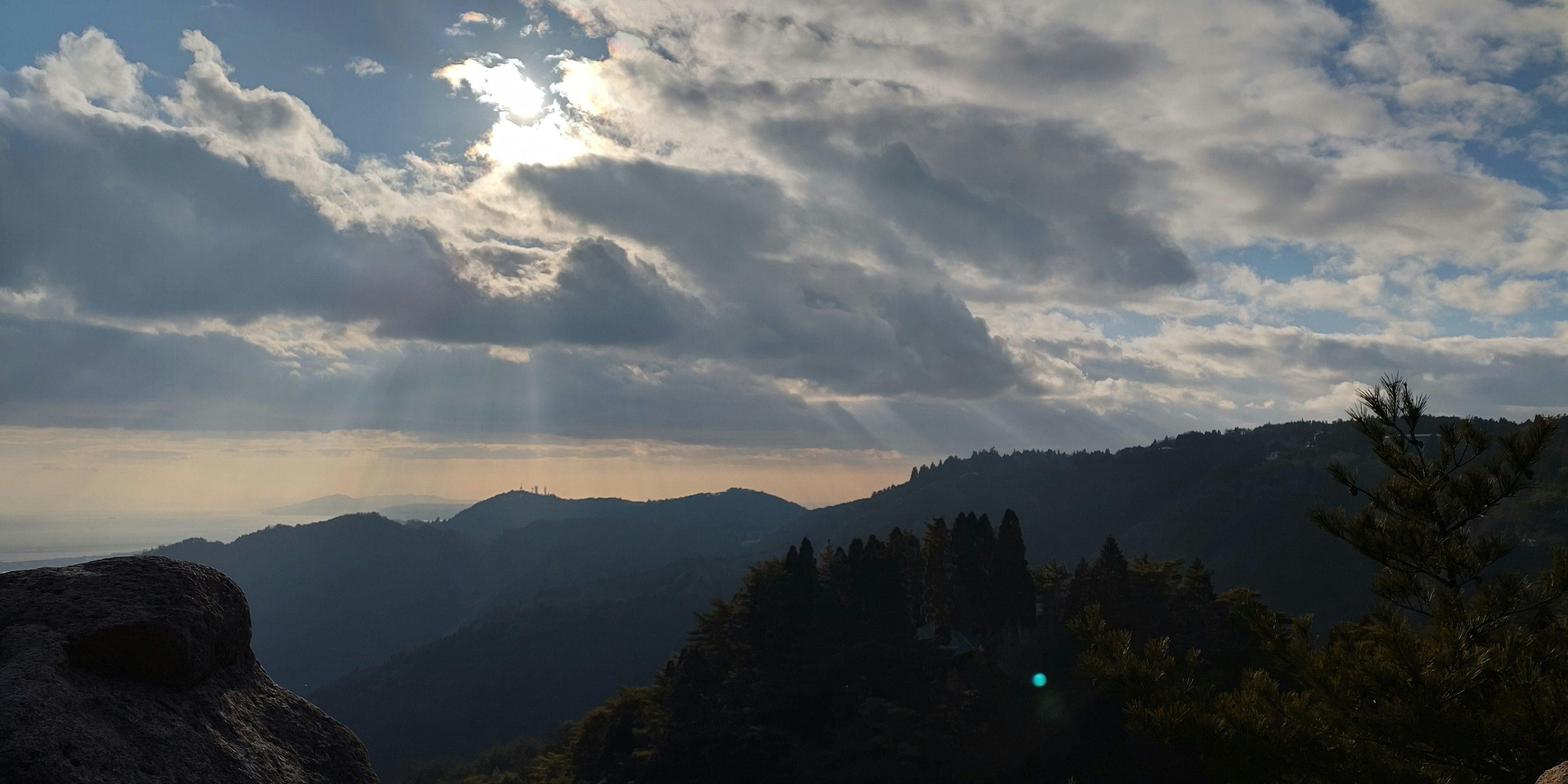 Vista panoramica di montagne con nuvole e raggi di sole