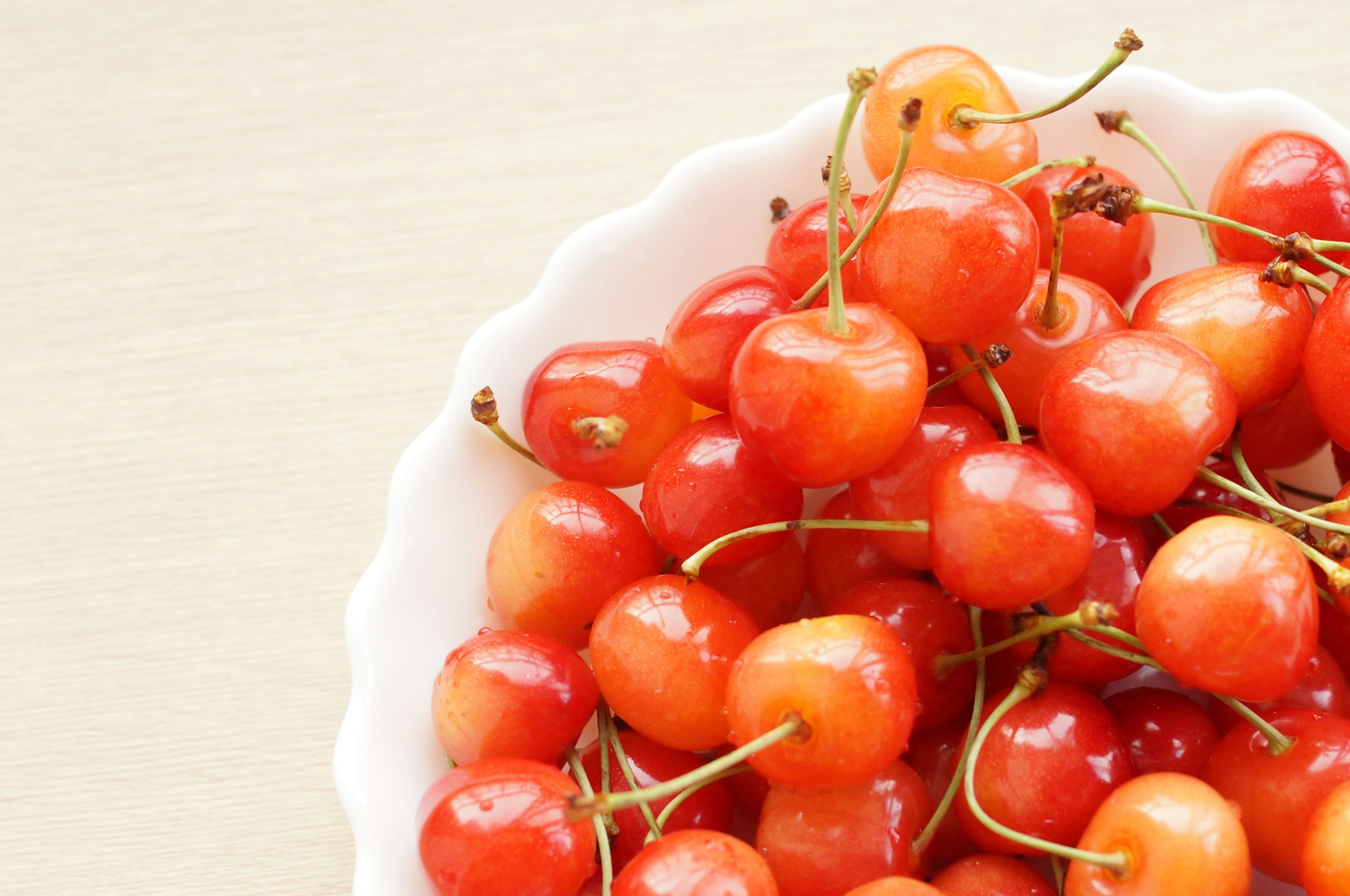 Vibrant red cherries arranged in a white bowl