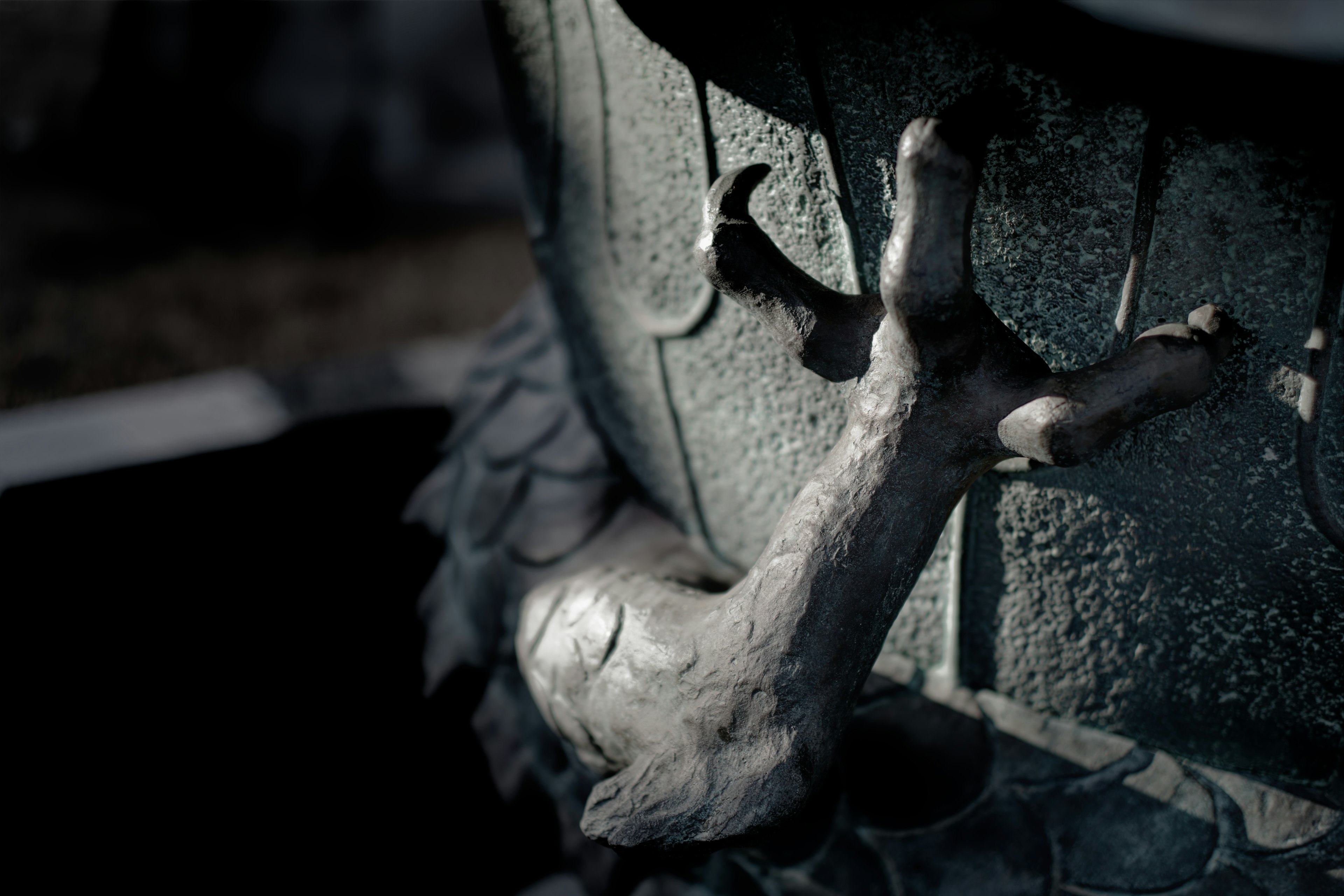 A close-up of a textured hand-like sculpture on a dark surface