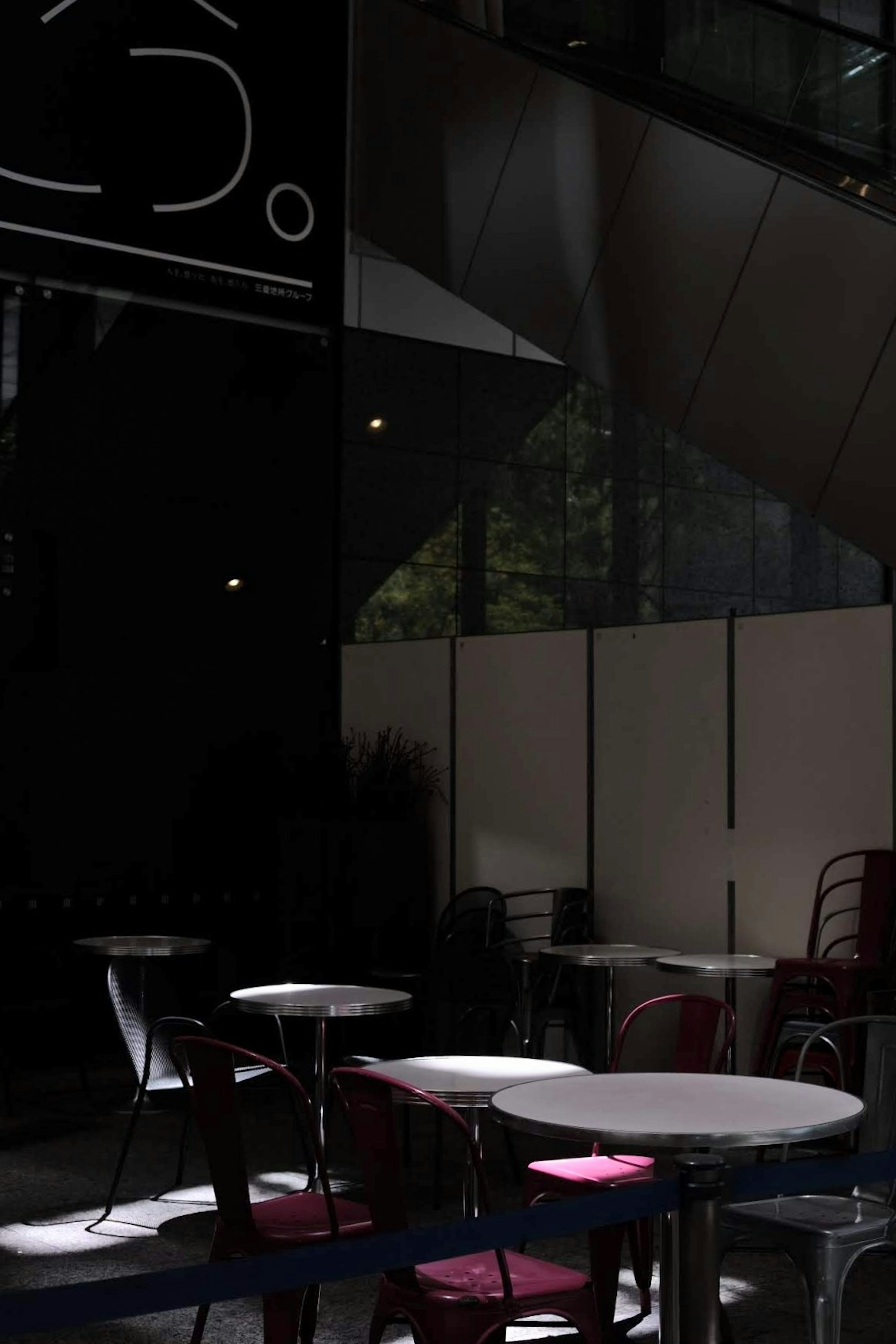 Terraza de café oscura con mesas redondas y sillas