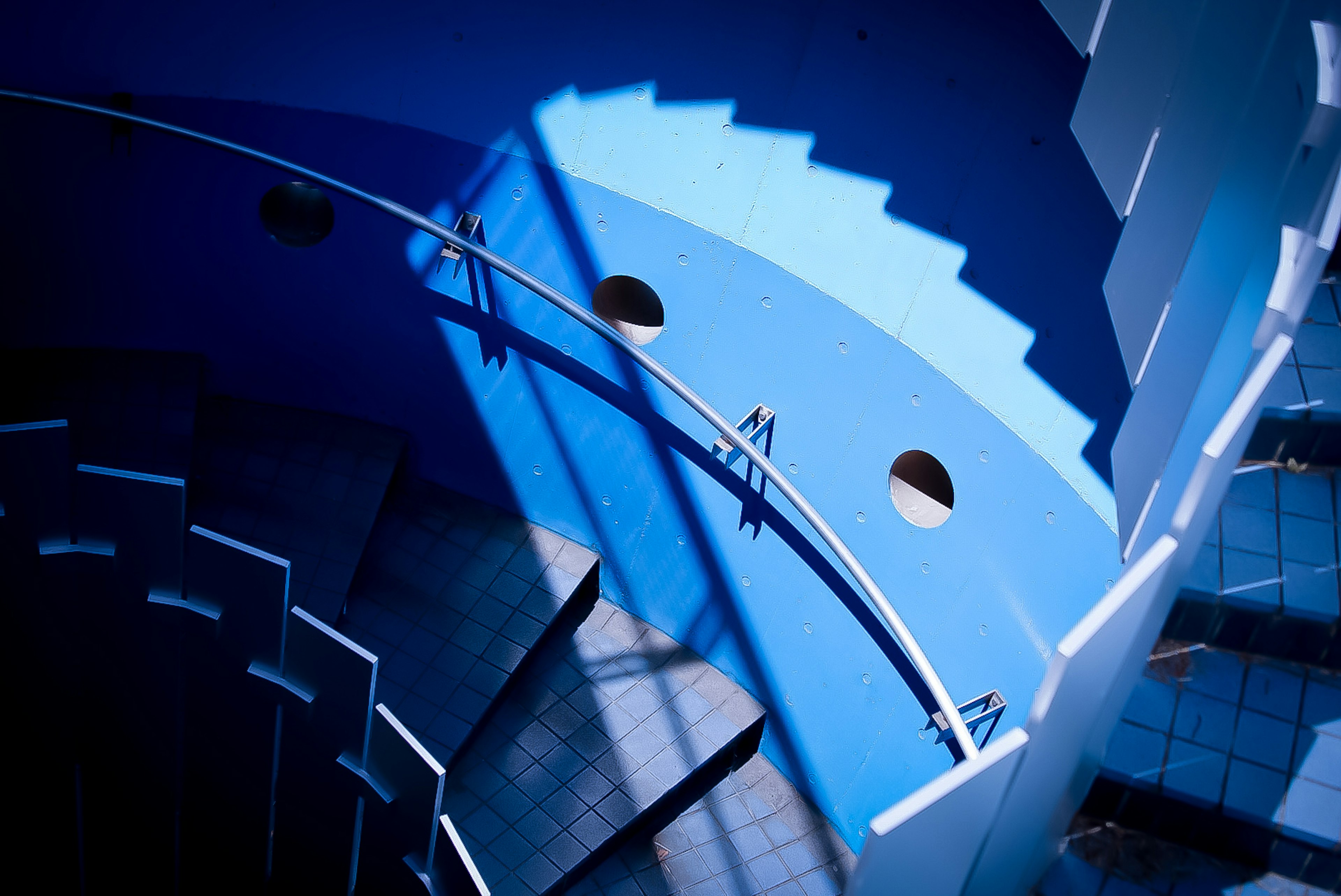 Top view of a blue spiral staircase with shadows