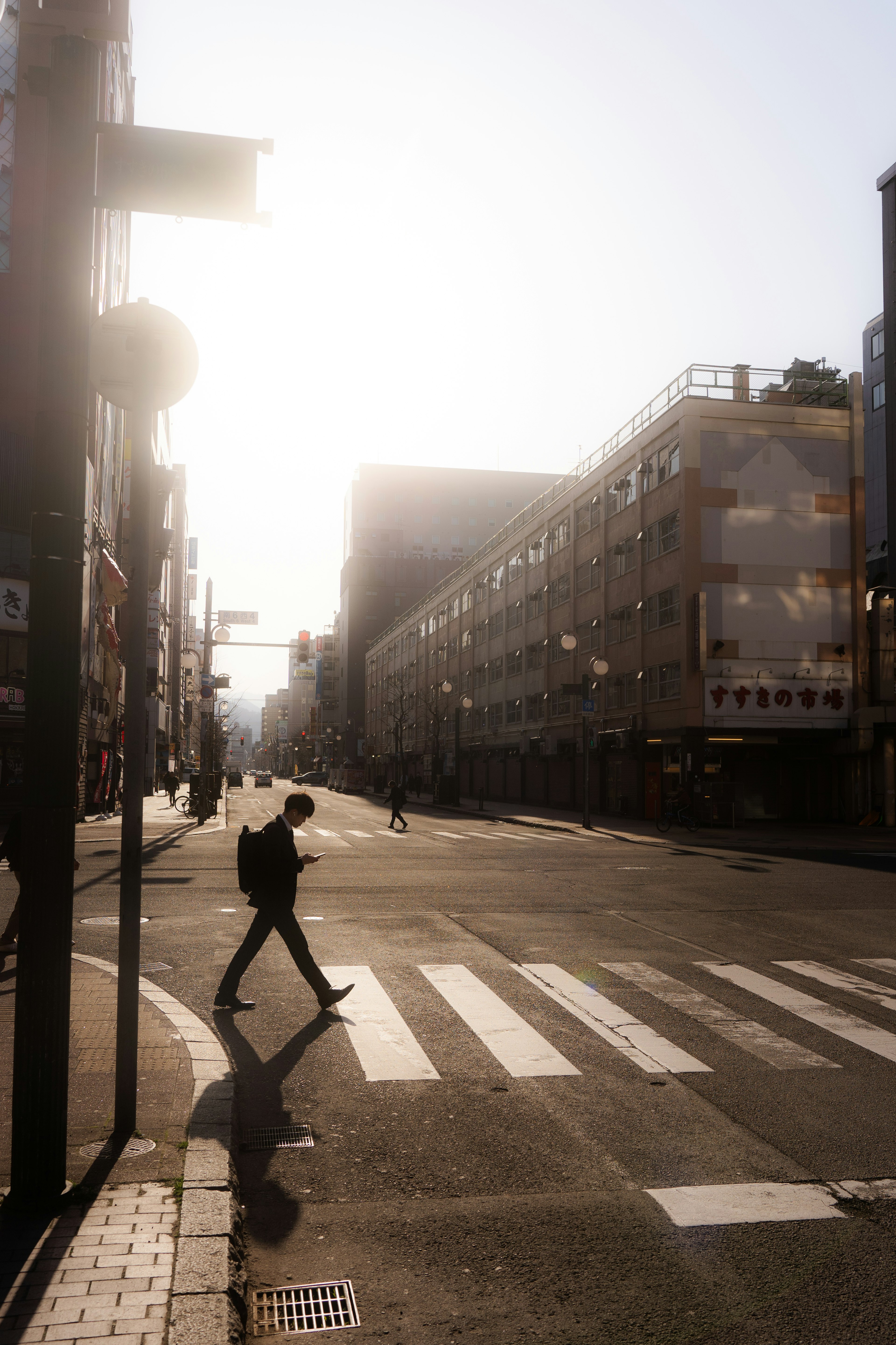 背对夕阳的男子在街道上过马路的轮廓