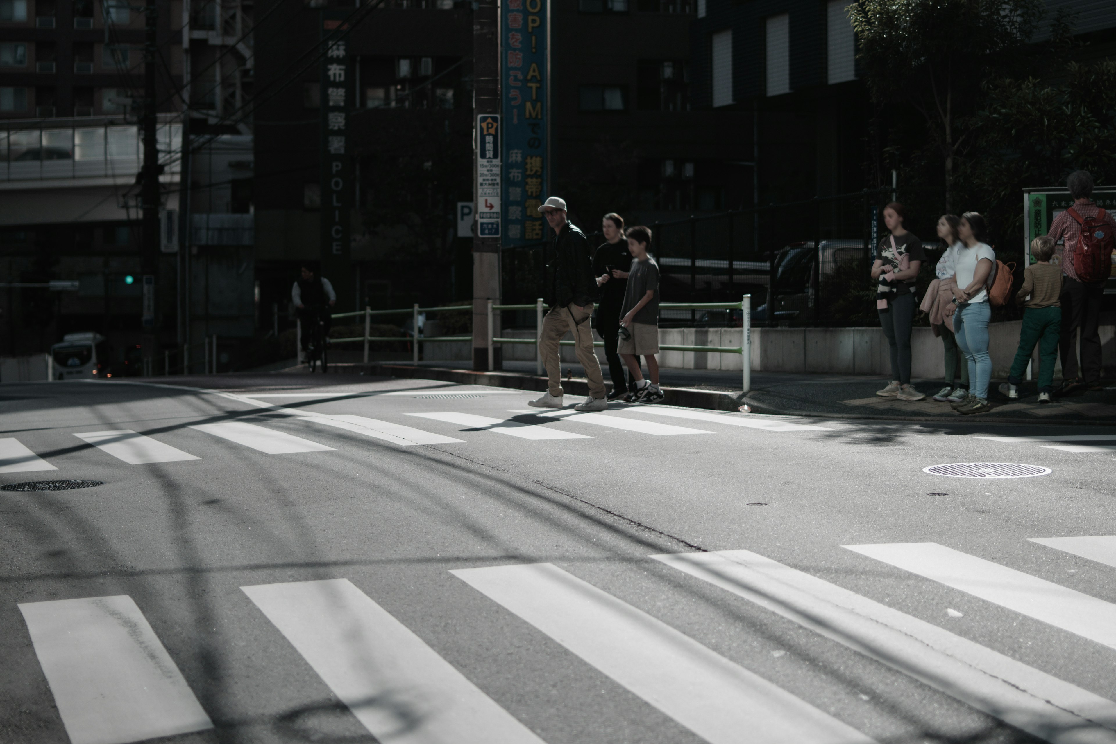 Urban scene with people waiting at a crosswalk young individuals enjoying street art