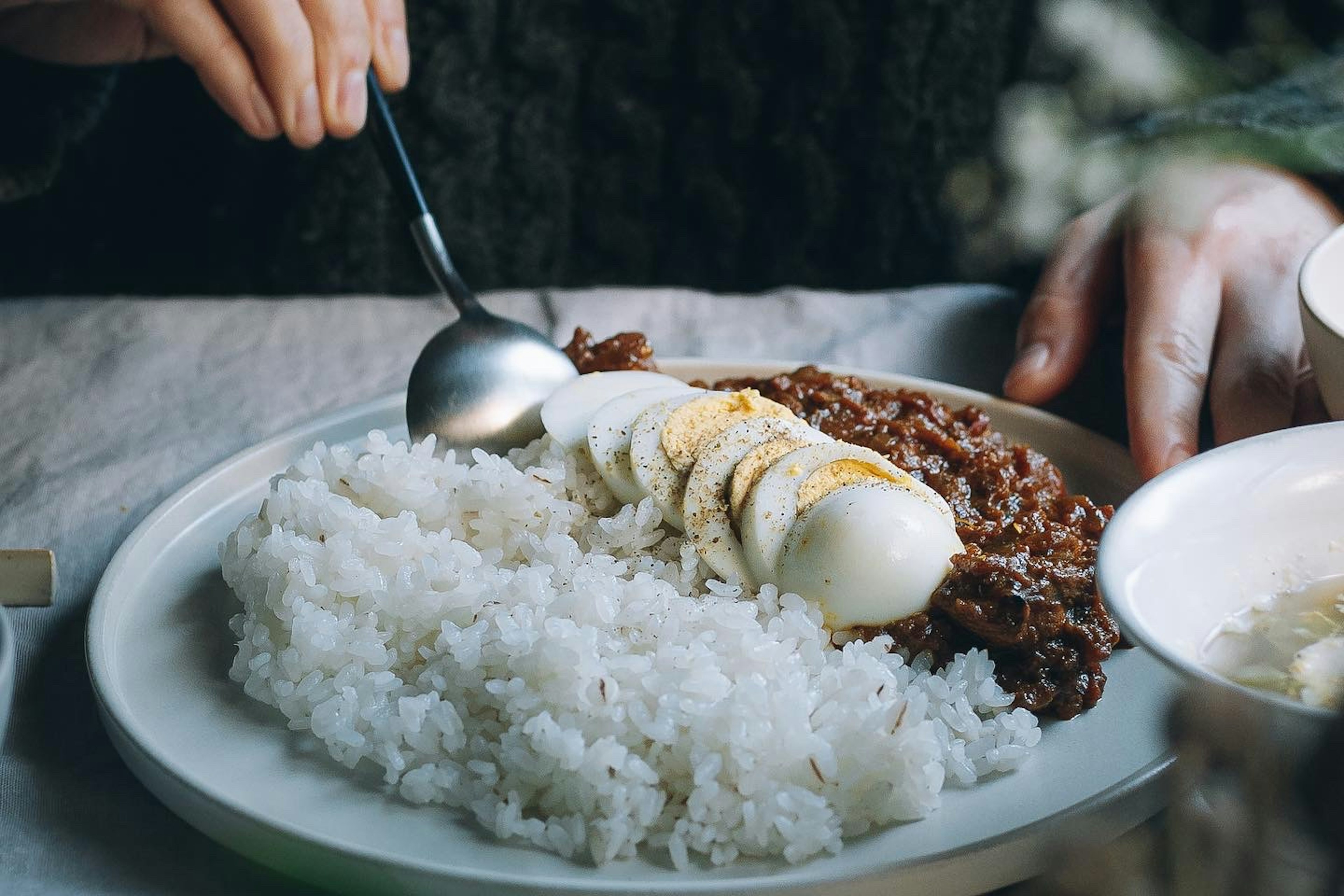 白いご飯とバナナをトッピングした肉料理のプレート