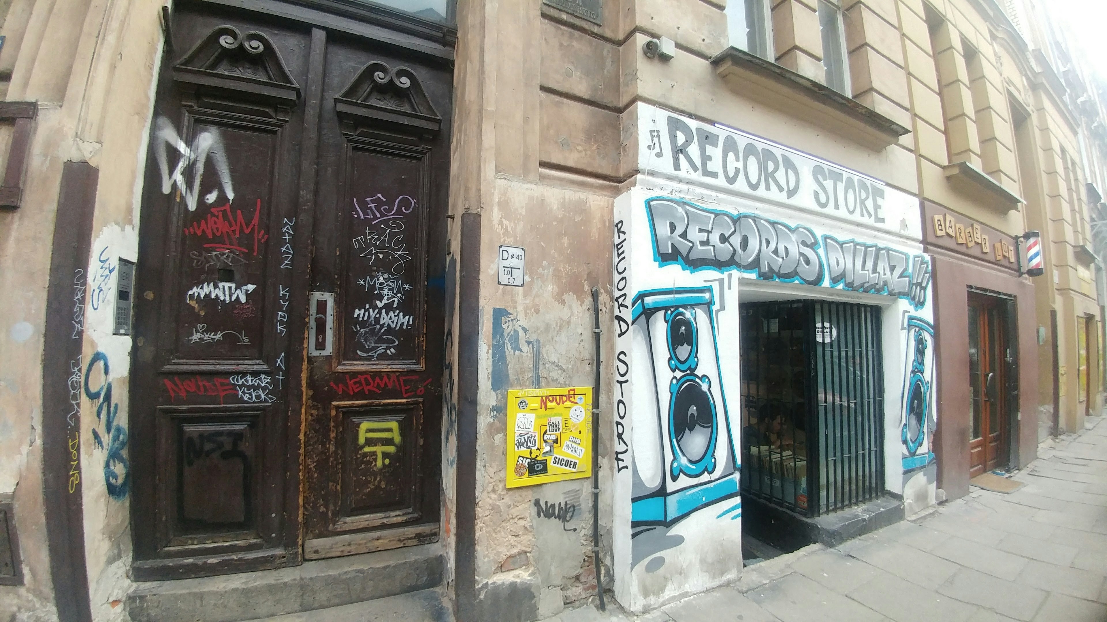 Façade d'un magasin de disques avec graffiti et une porte en bois