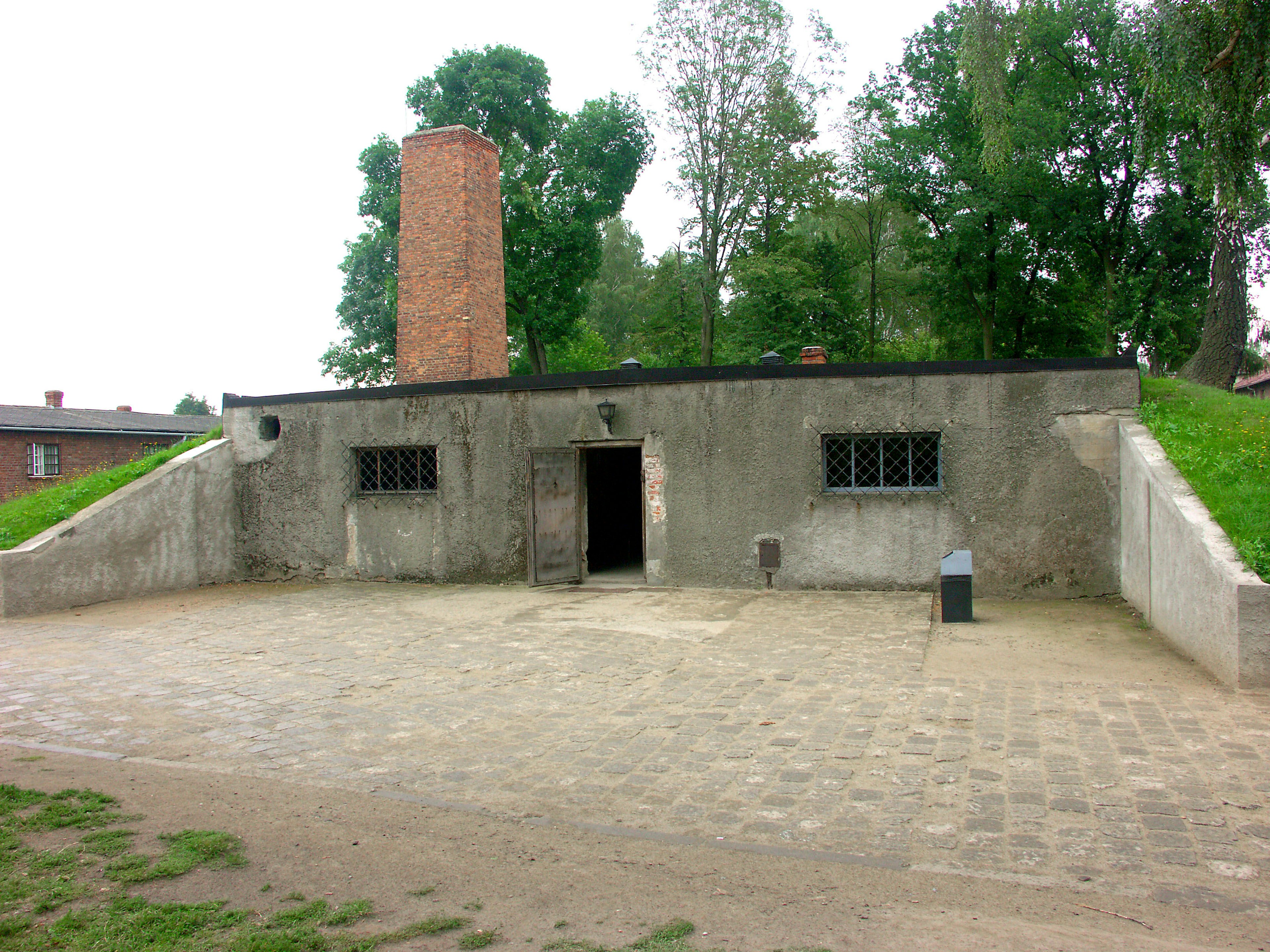 Gray wall building with a black roof and chimney visible entrance part of a historical site