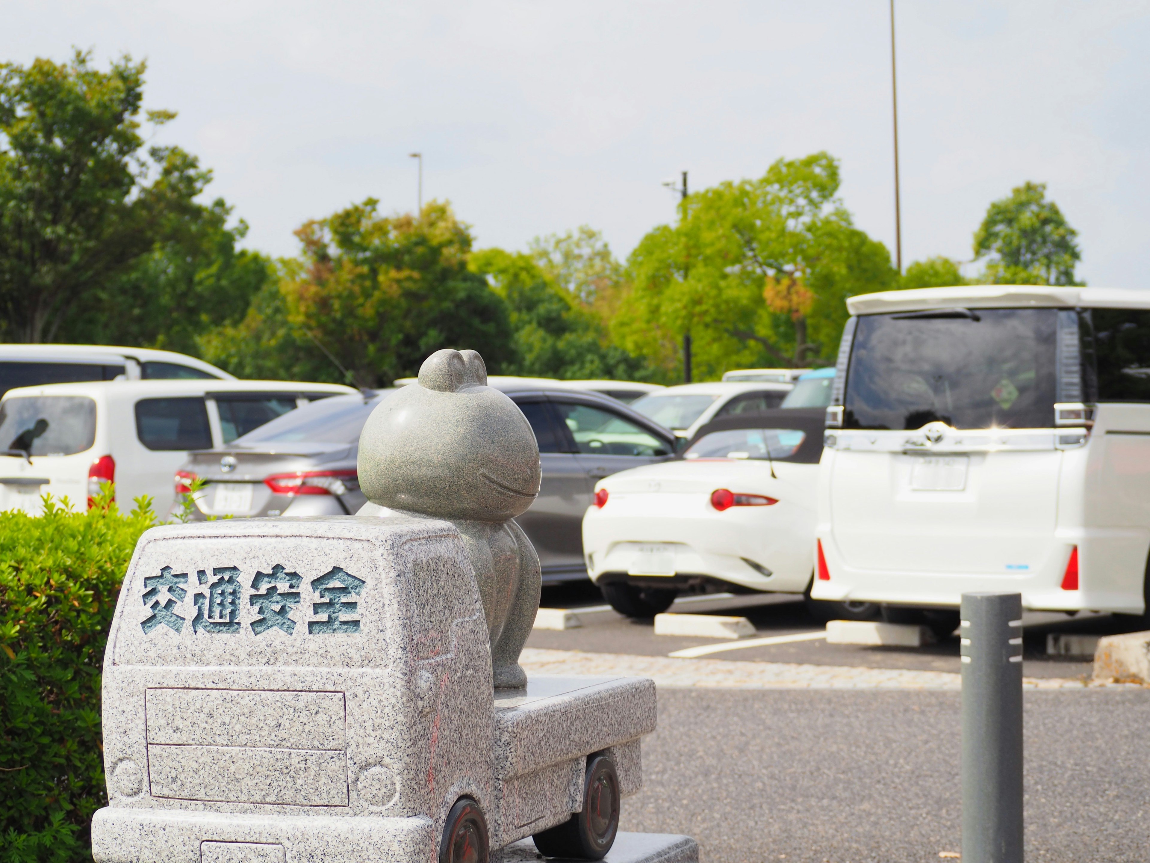 駐車場にある石のオブジェと車の風景