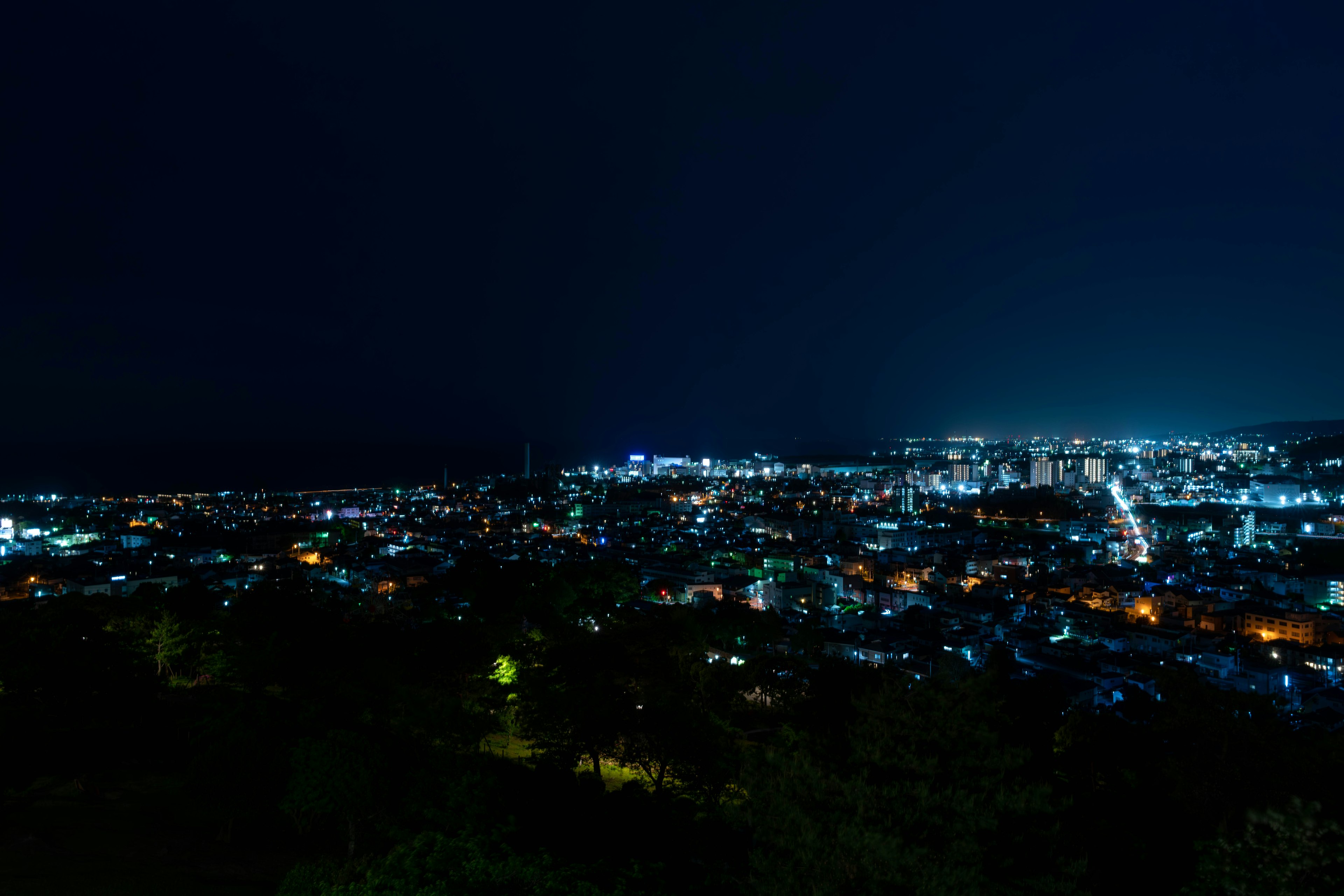 Night cityscape featuring bright street lights and illuminated buildings