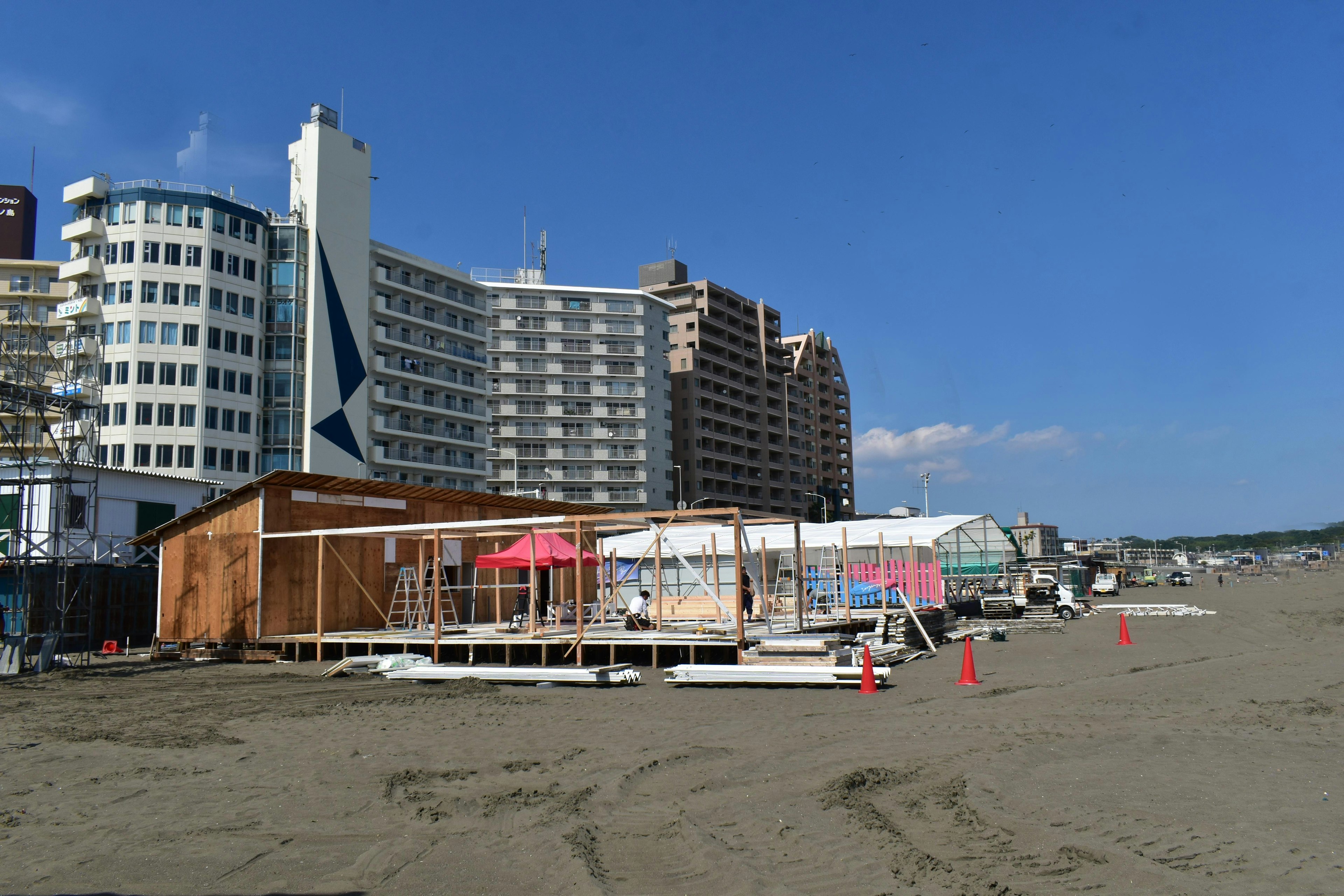 Escena de playa con un sitio de construcción y edificios altos