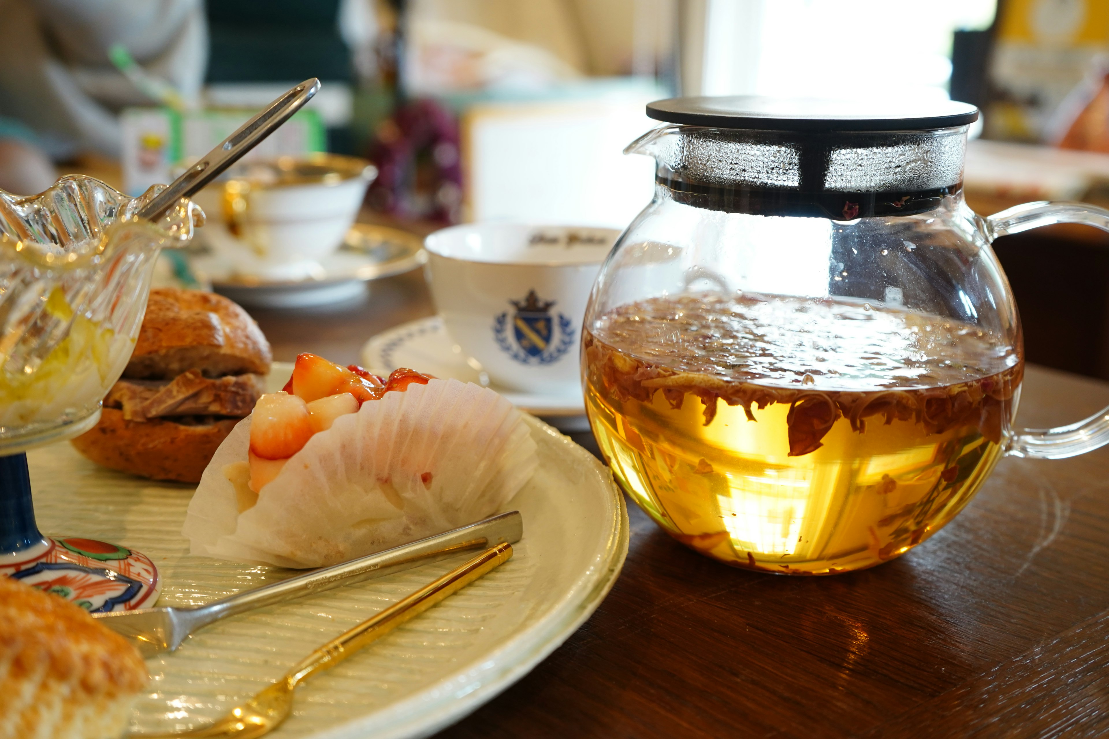 Une table avec une théière et une assiette de douceurs