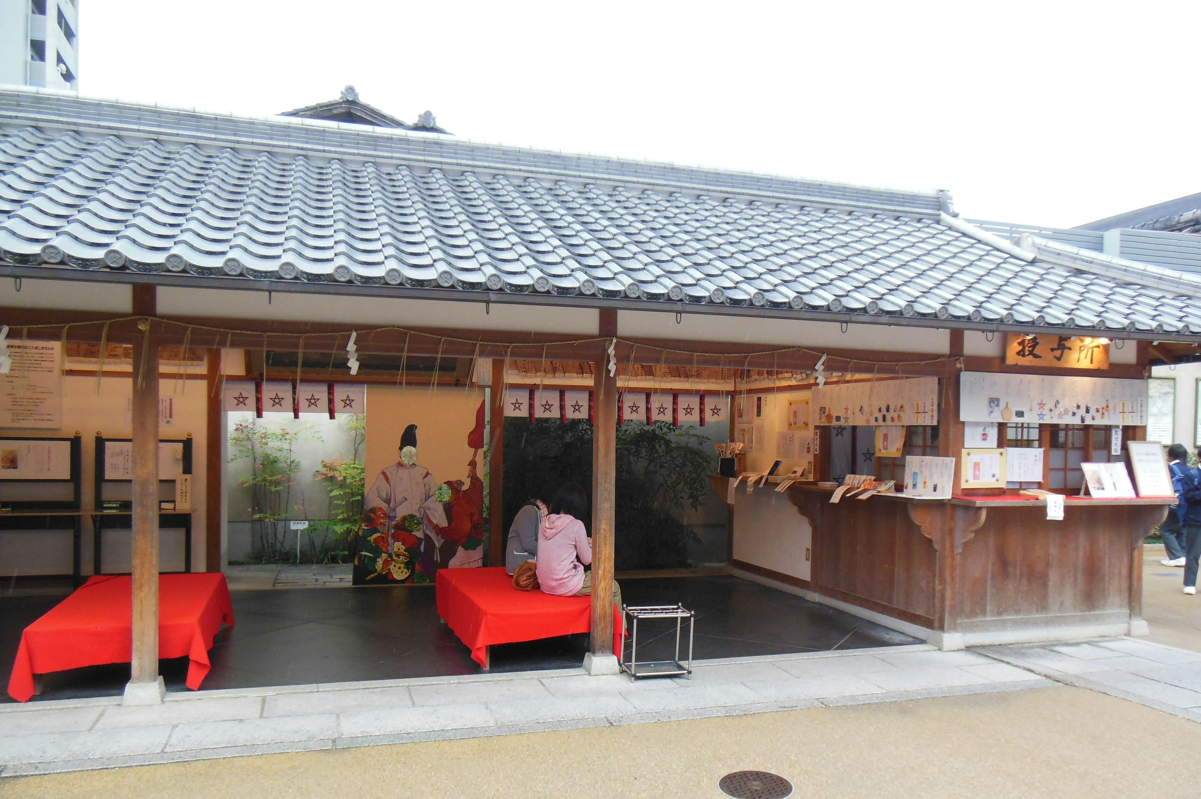 Exterior de un edificio japonés tradicional con mesas y sillas rojas