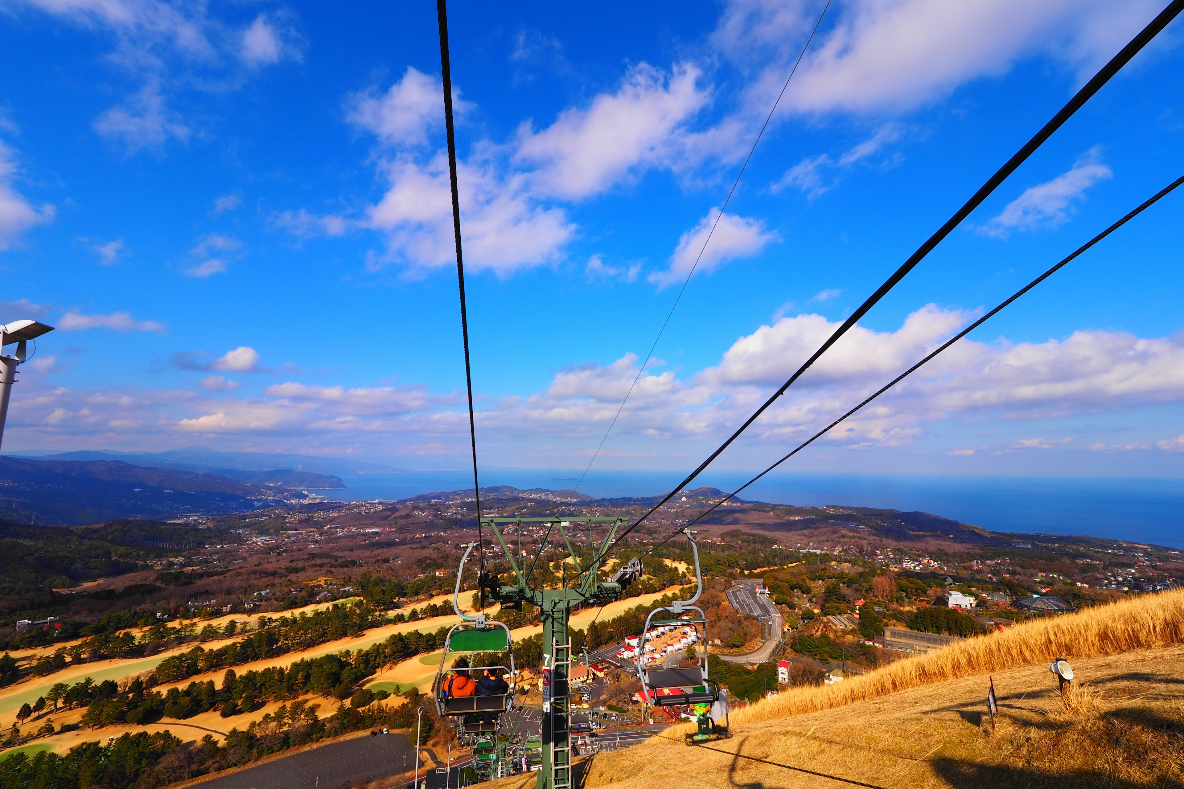 Vista desde un telesilla sobre un paisaje pintoresco con cielo azul y océano