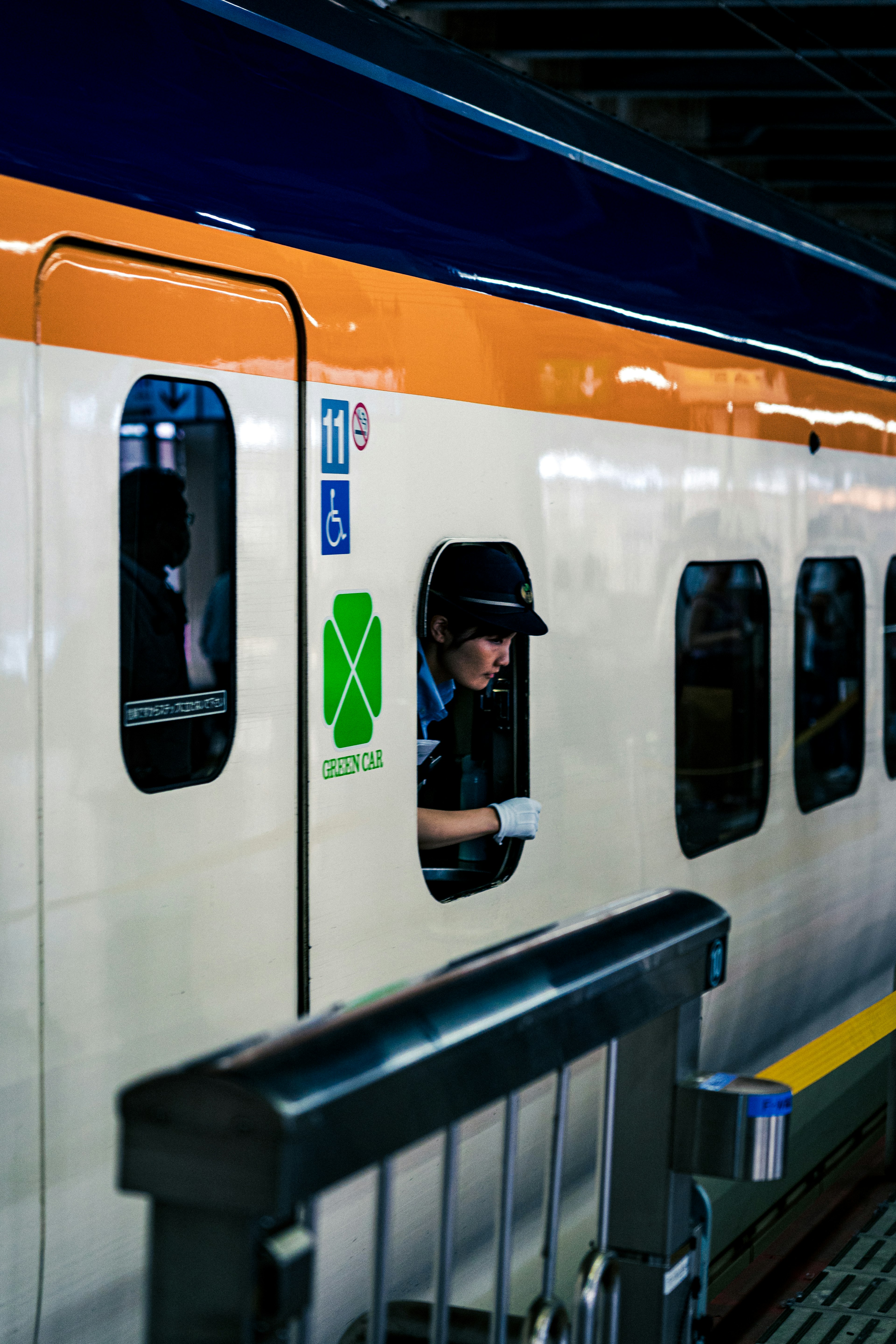 電車の窓から顔を出す駅員