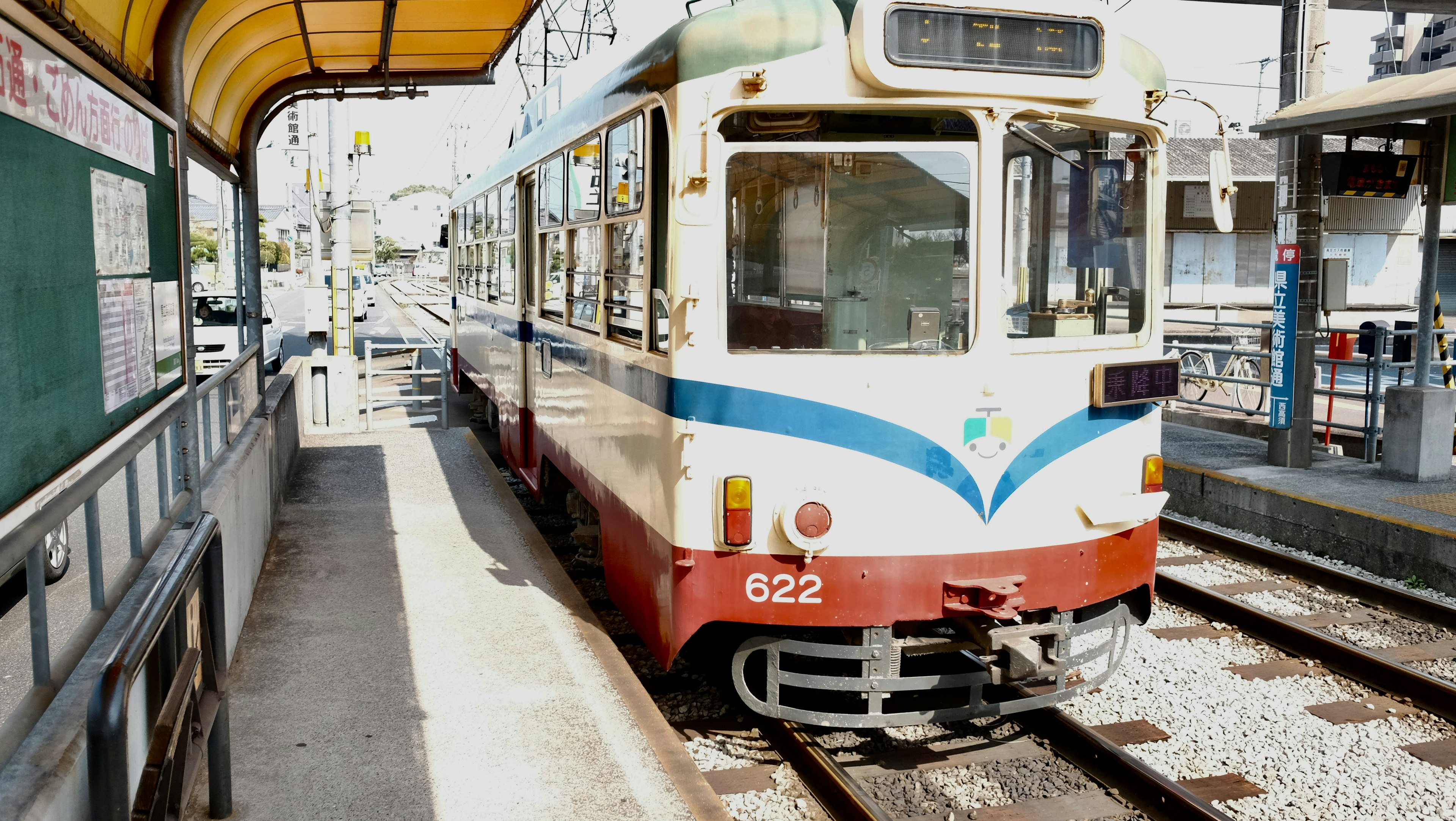 Tram che si ferma a una stazione tram colorato e struttura della stazione