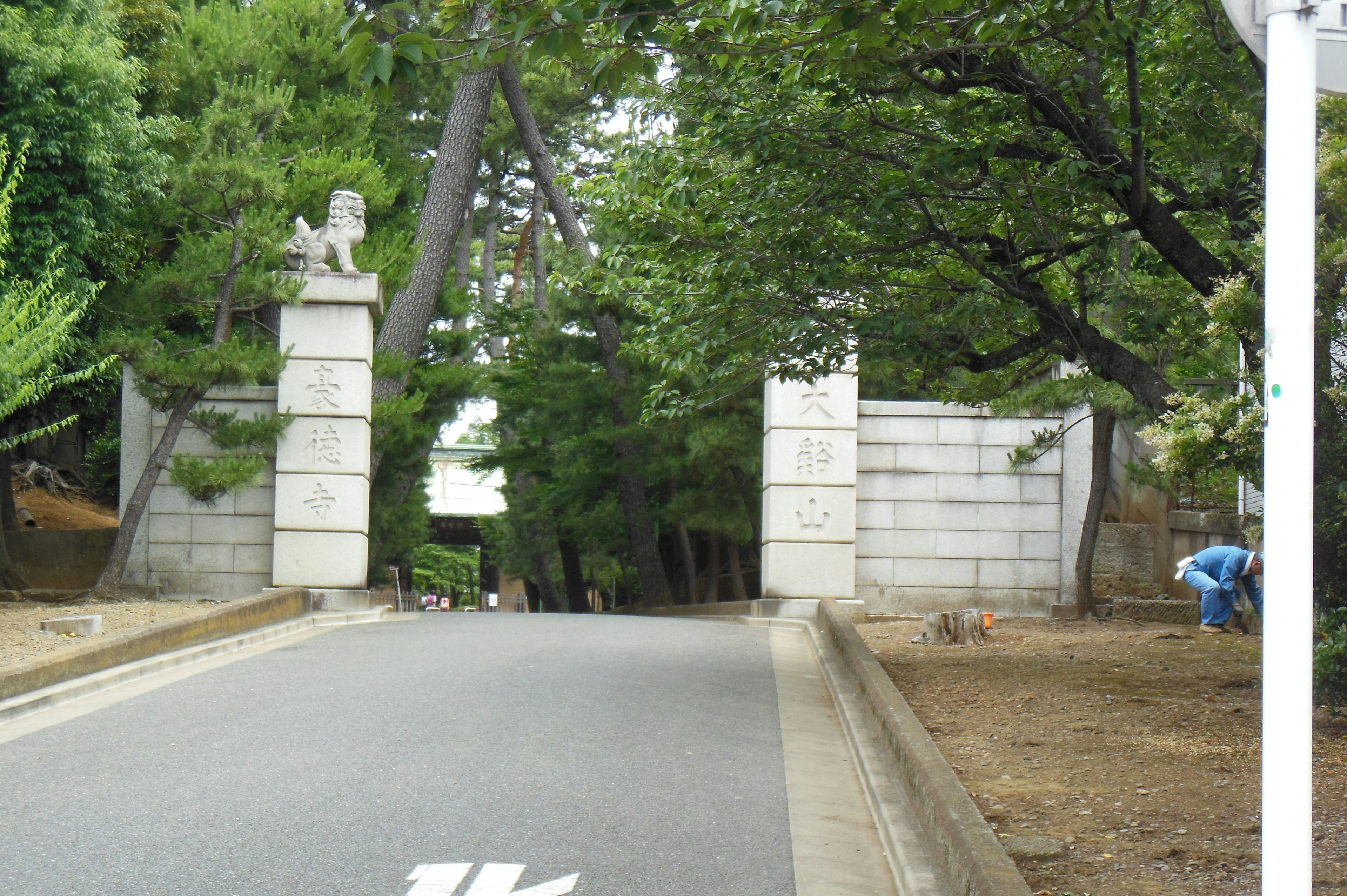 녹지에 둘러싸인 돌문과 그 뒤의 길