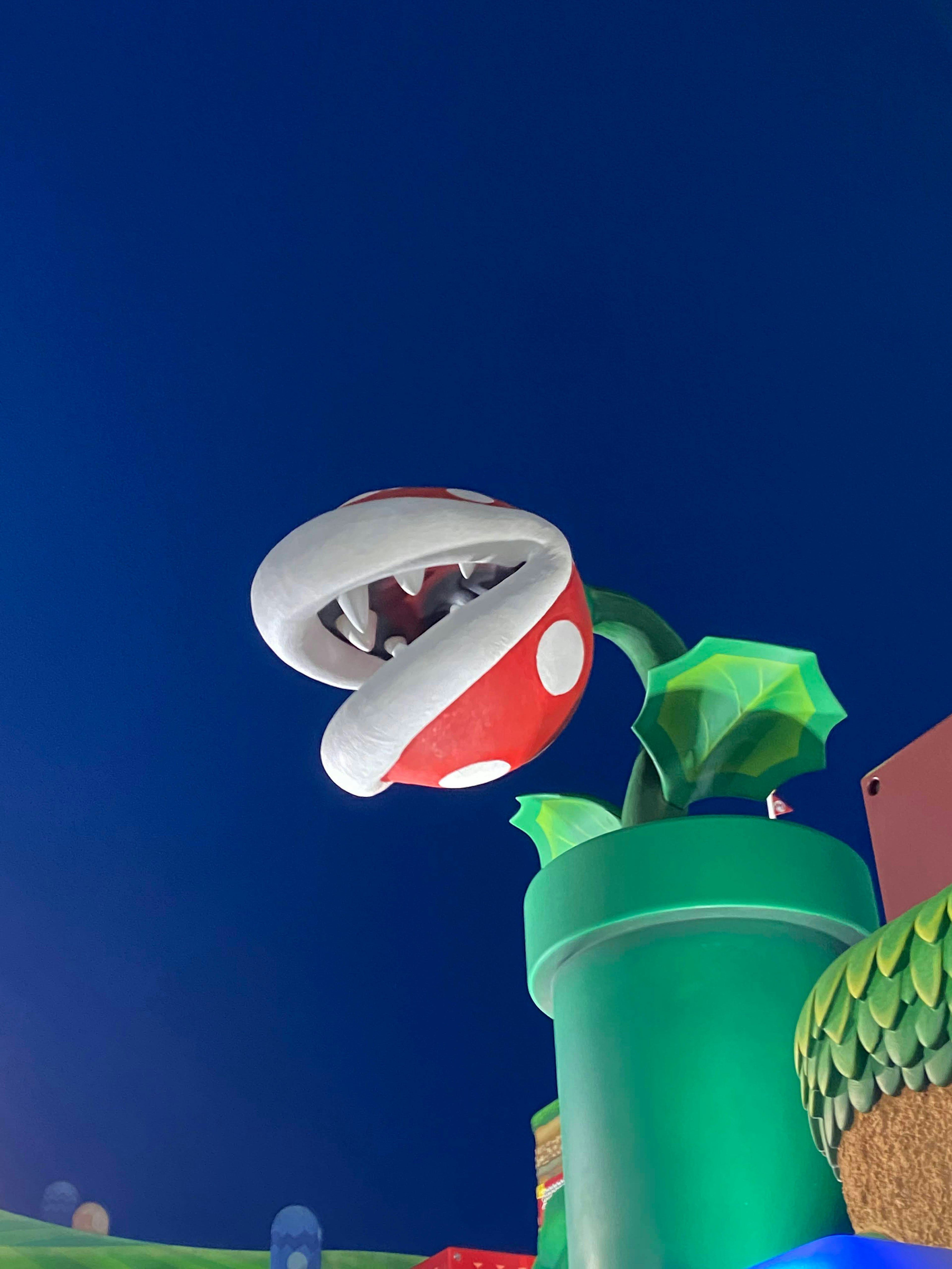 Piranha Plant with red and white spotted mouth emerging from green pipe