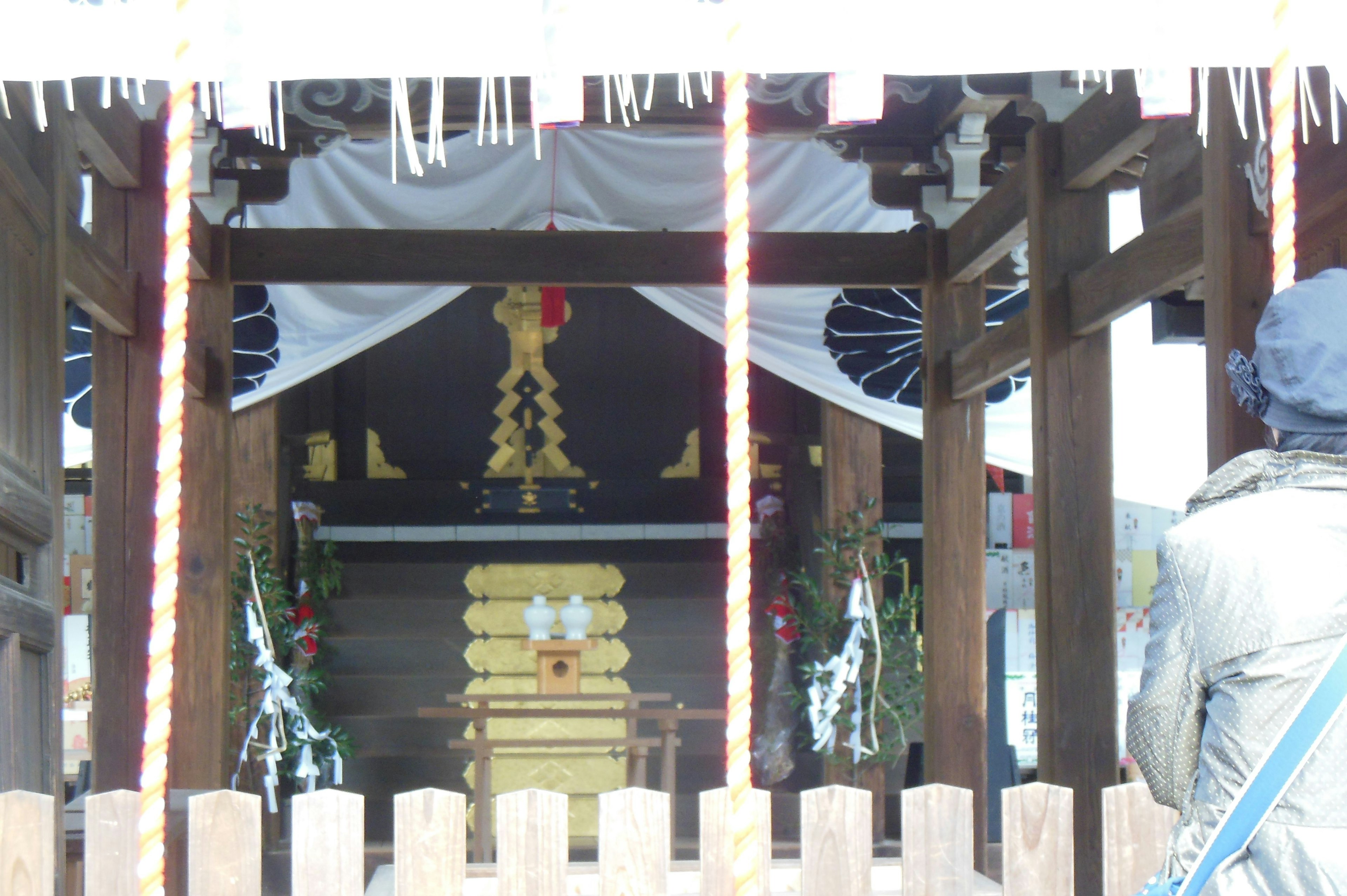 图像显示一个神社的内部，金色祭坛装饰着白色花朵