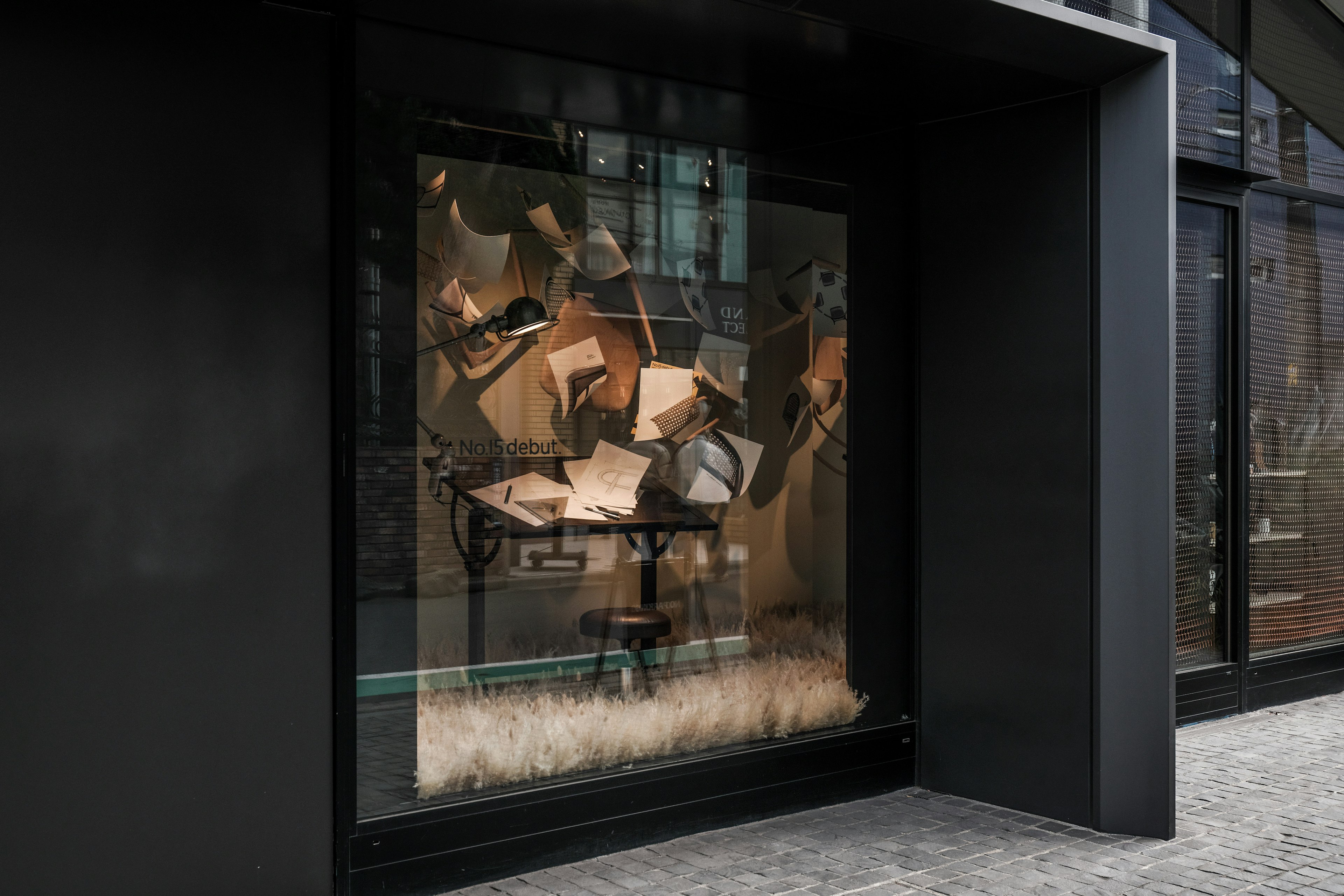 Installation artistique dans une vitrine de magasin avec des livres flottants et une table