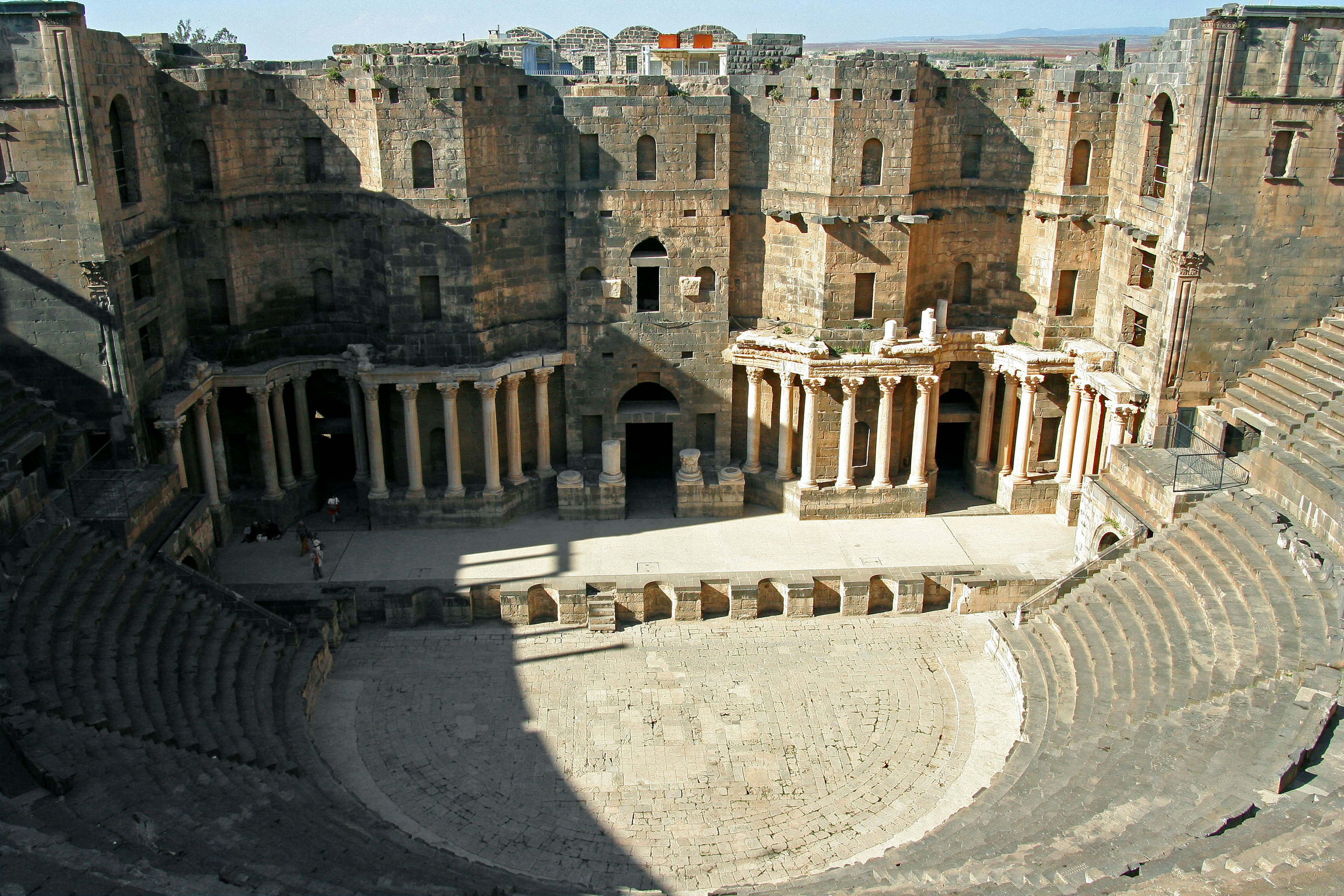 Vista interna di un antico teatro romano con rovine e posti a sedere circolari