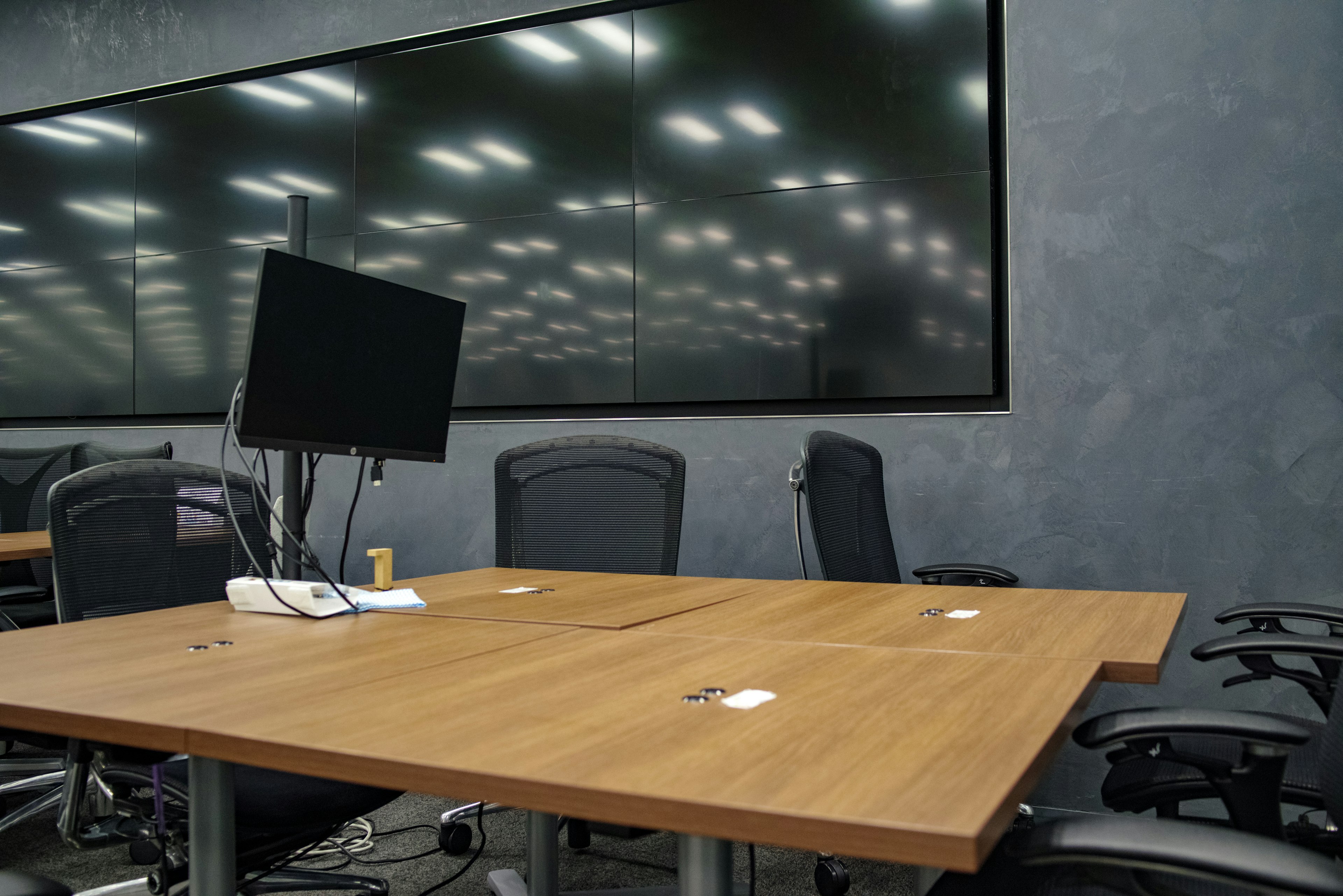 Sala de conferencias moderna con mesa de madera y monitor