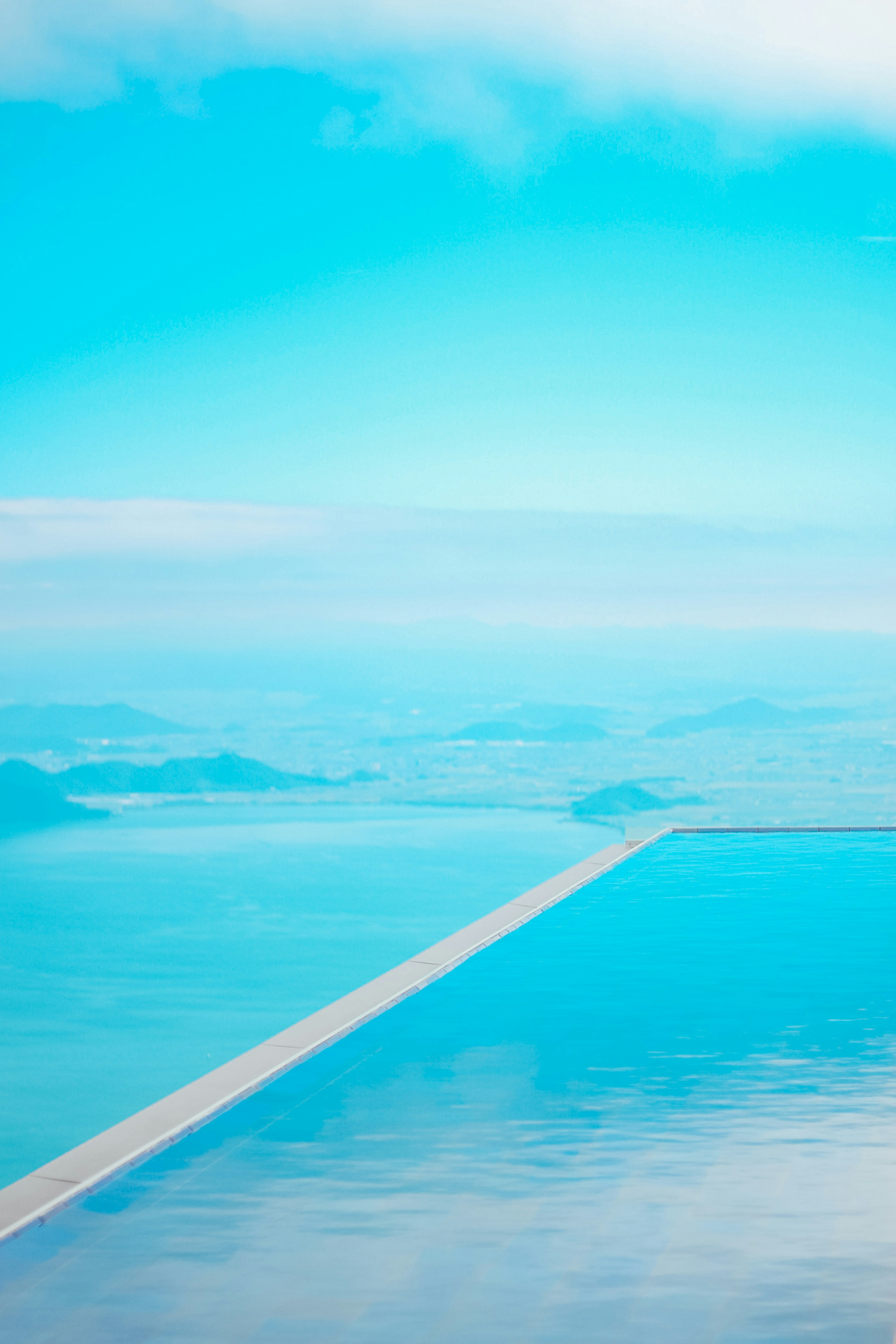 Un lungo sentiero si estende su un mare blu sereno sotto un cielo limpido