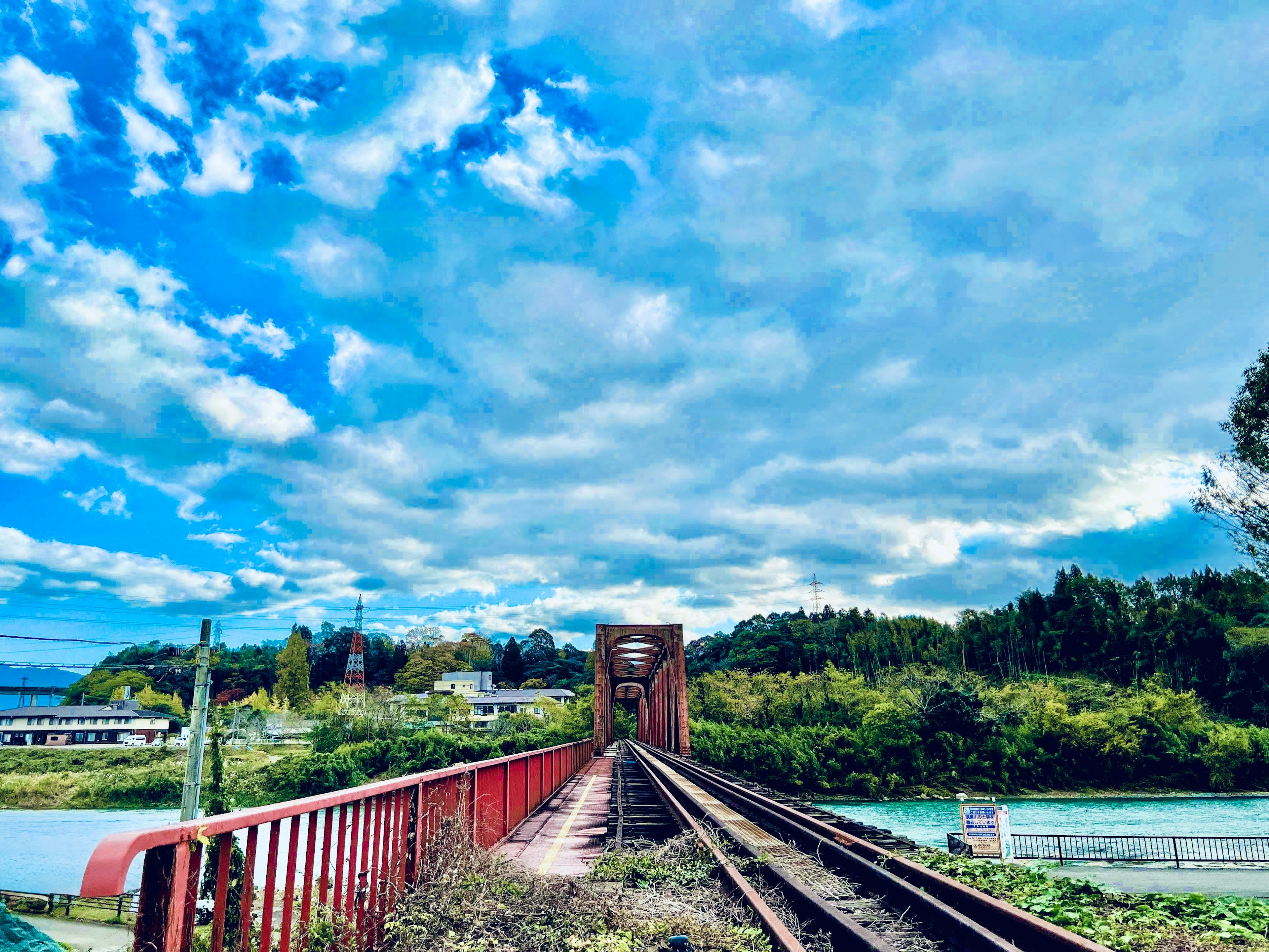 Rote Eisenbahnbrücke und Gleise unter einem blauen Himmel