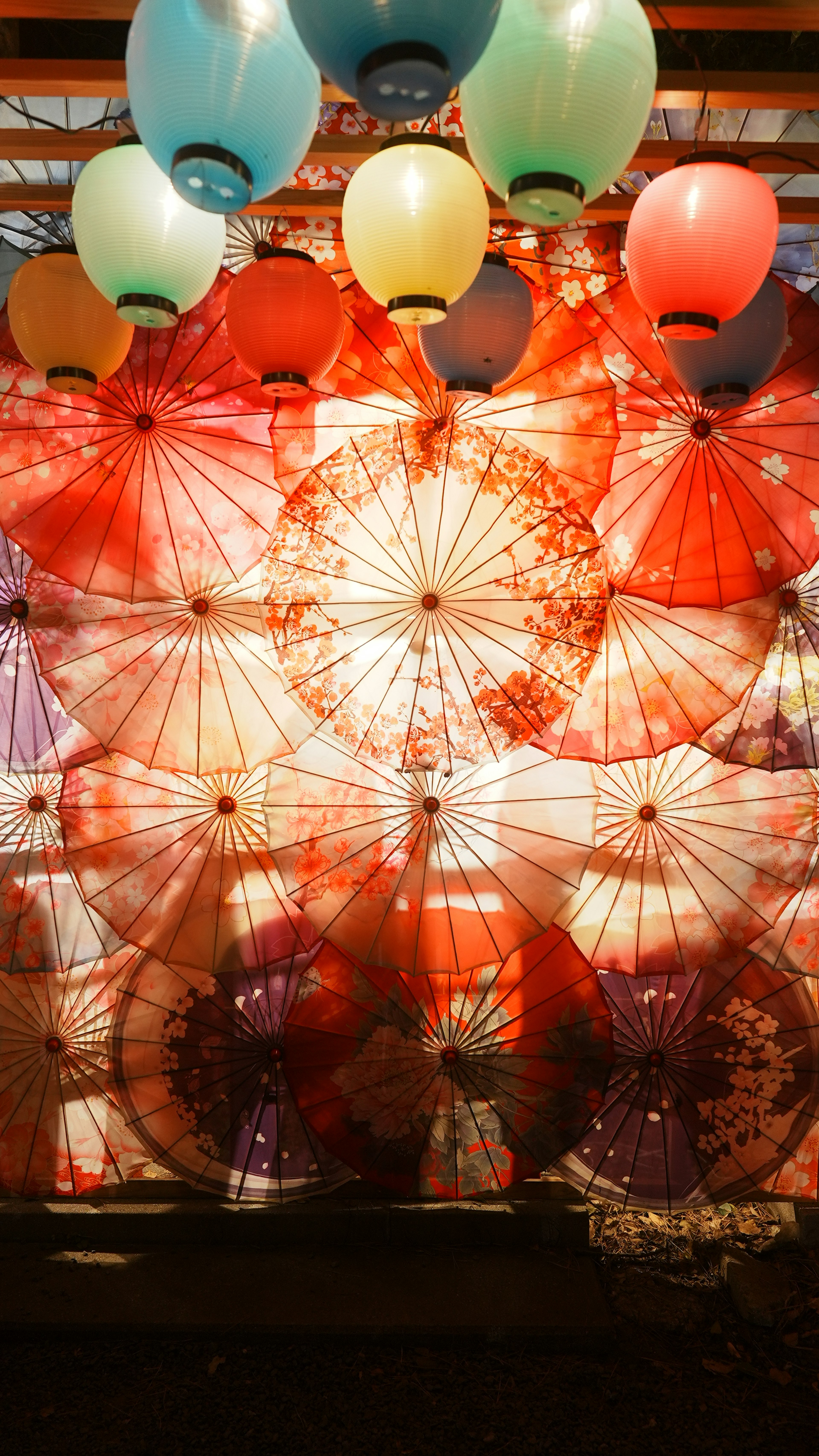 Colorful umbrellas arranged in a backdrop with balloons floating above