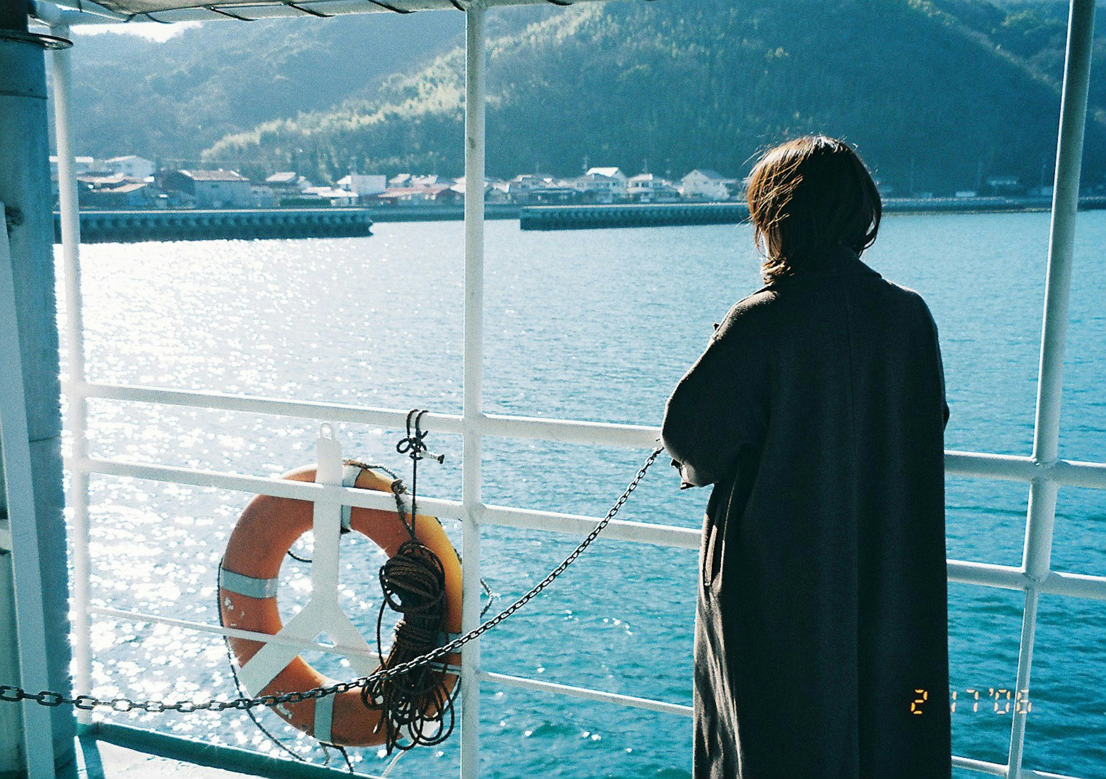 Person schaut auf das Meer mit einem Rettungsring im Blick